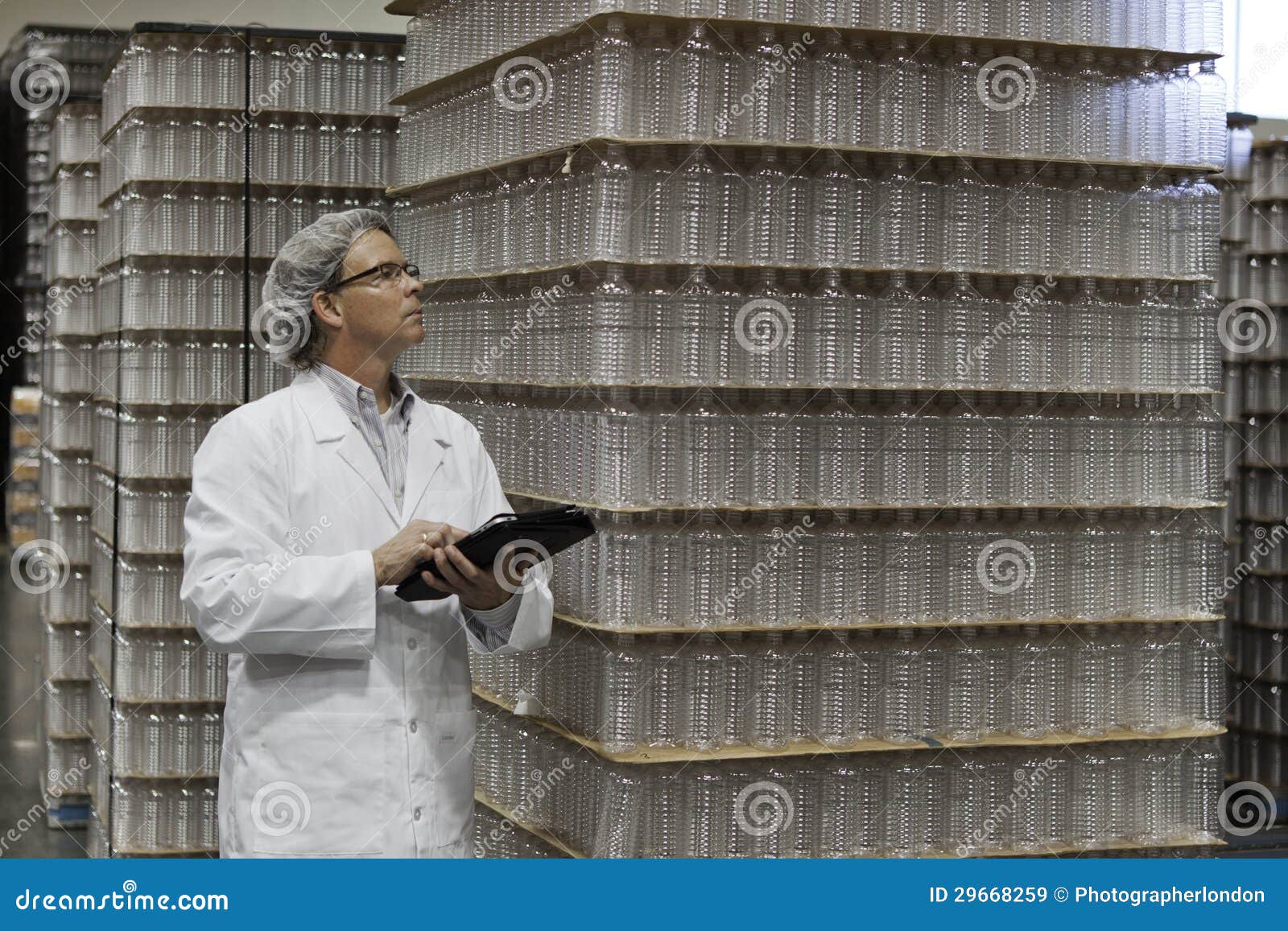 Man Inspecting Bottled Water in Distribution Warehouse Stock Image