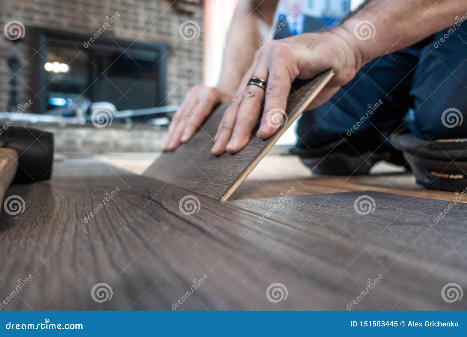 man installing engineered laminate wood floring indoor