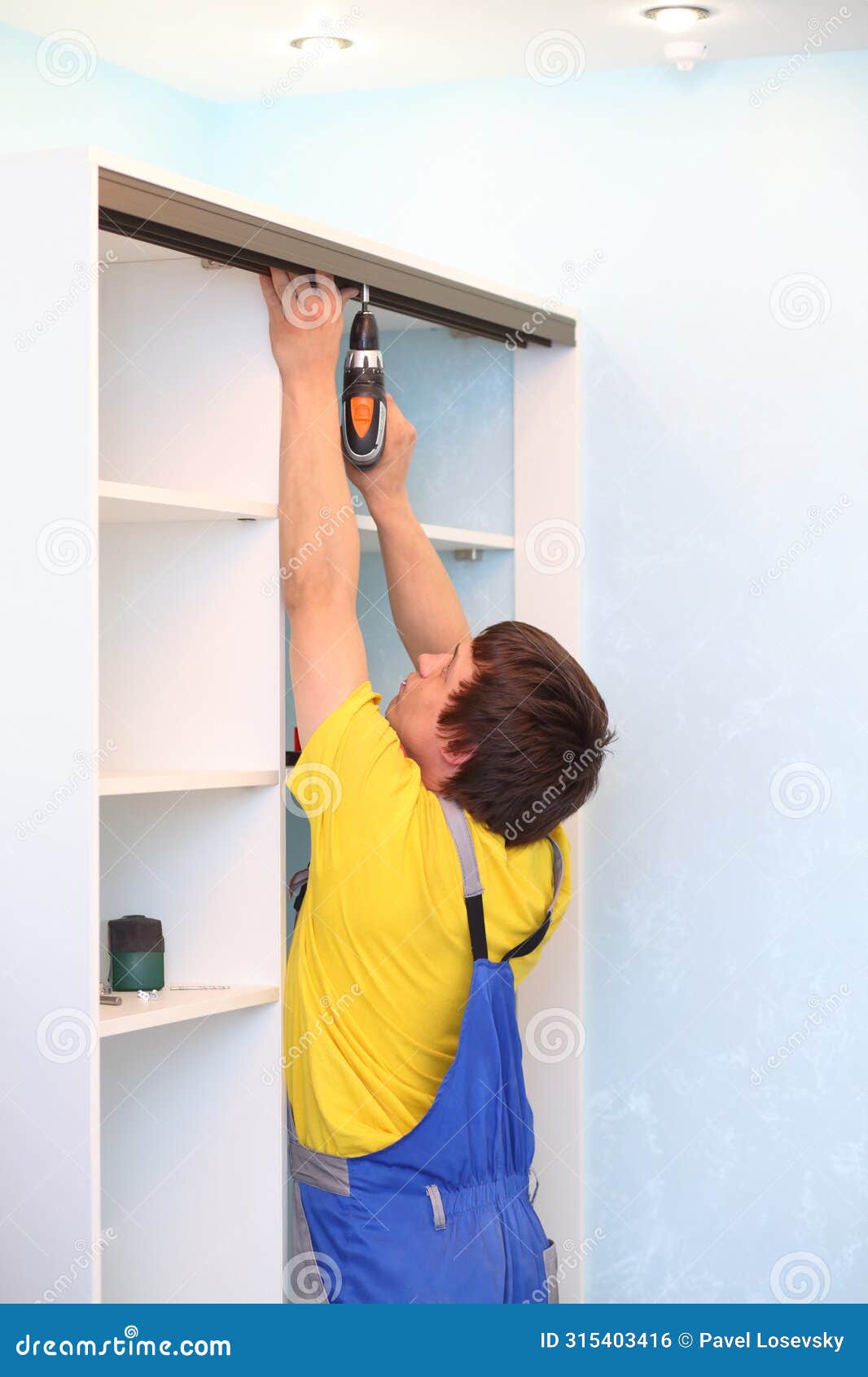 man installing guide rails for sliding wardrobe in