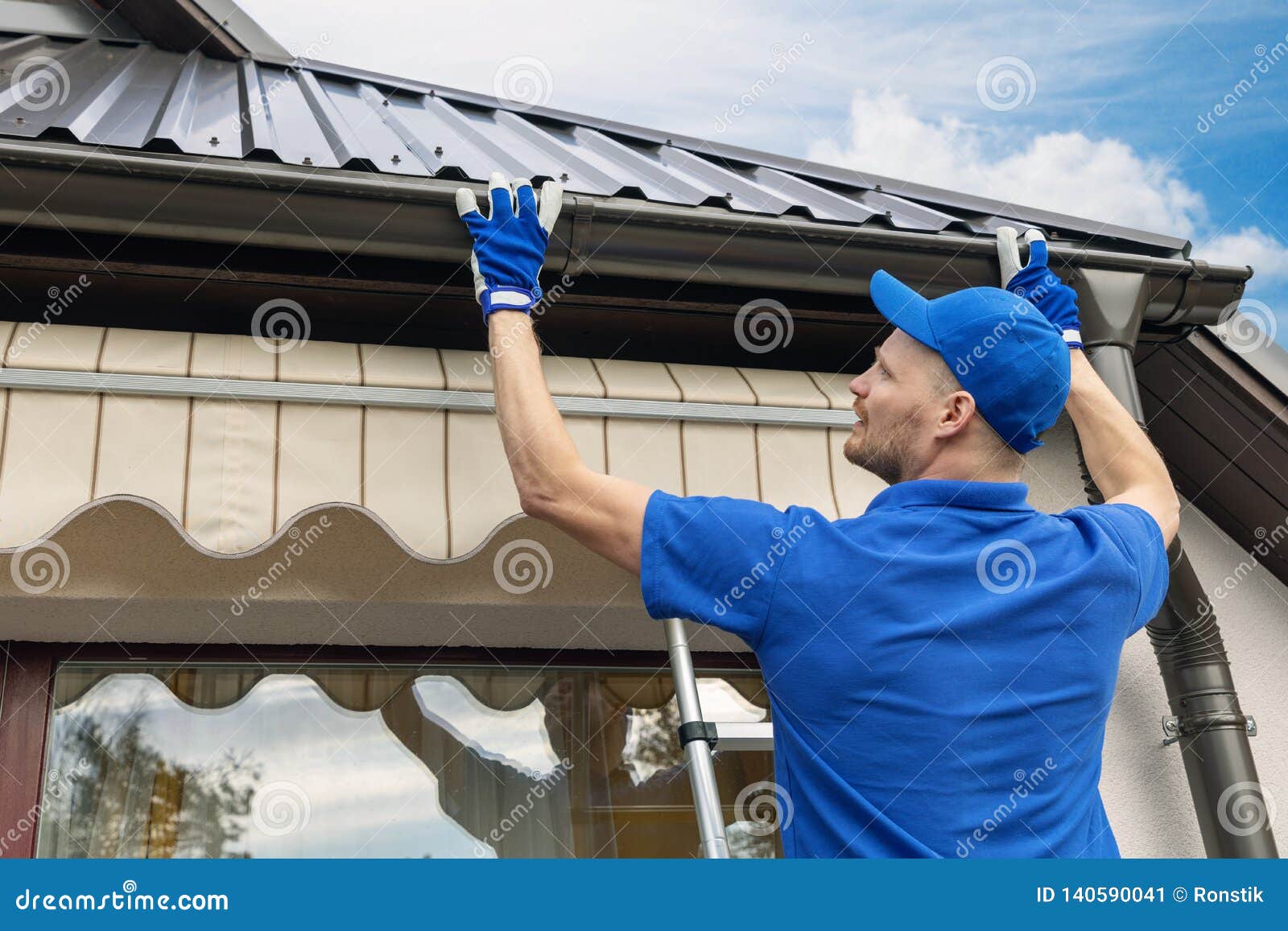 man installing house roof gutter system