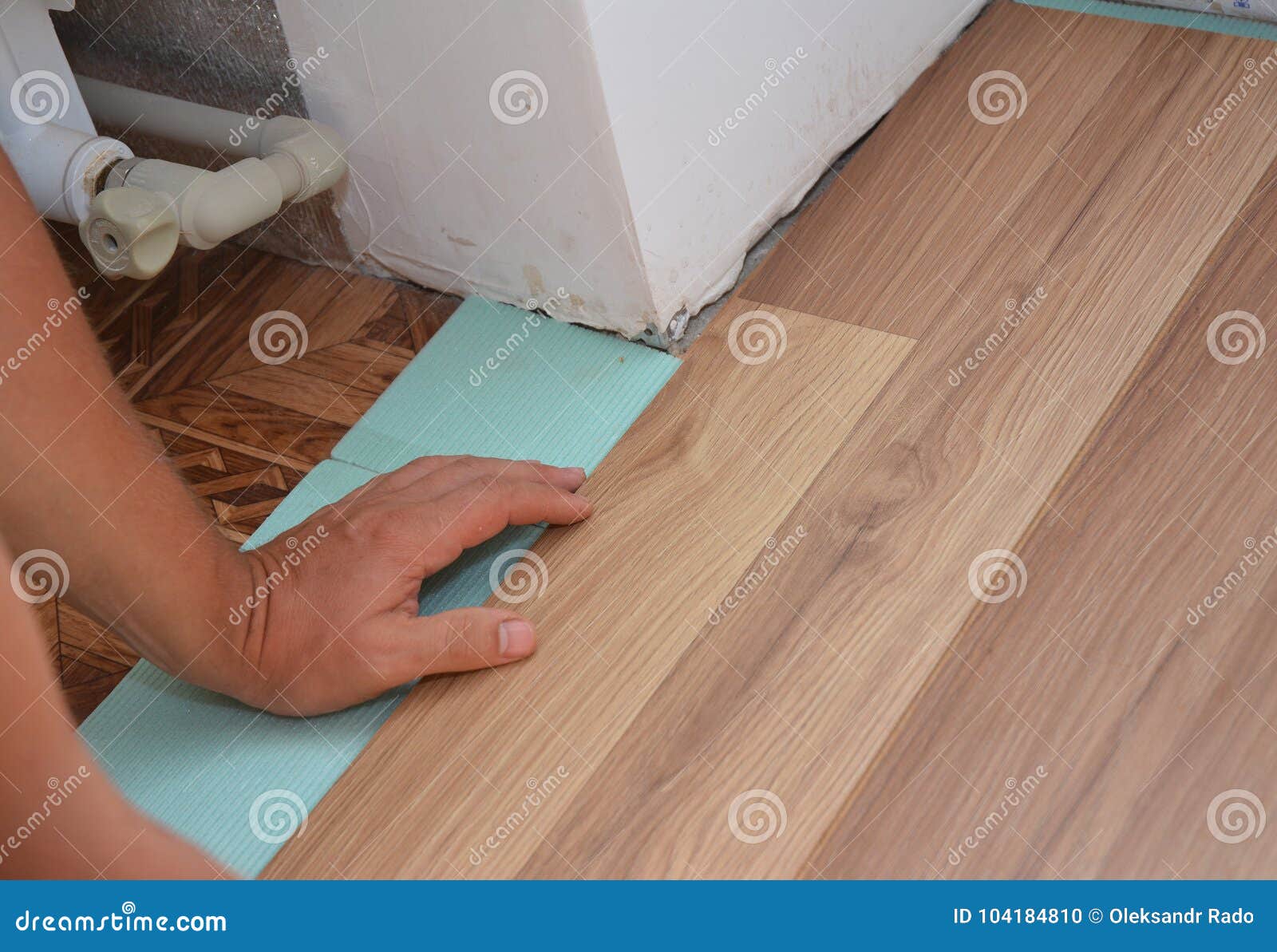 Man Installing Laminate Wood Flooring In Problem Area Worker