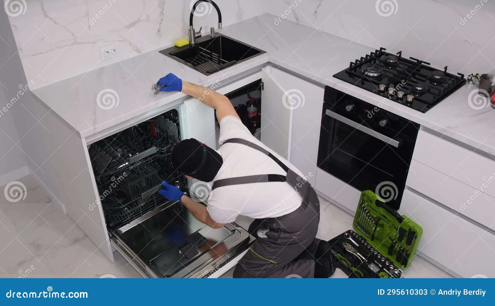 A Man Installs a New Dishwasher in the Kitchen Room Stock Video Video