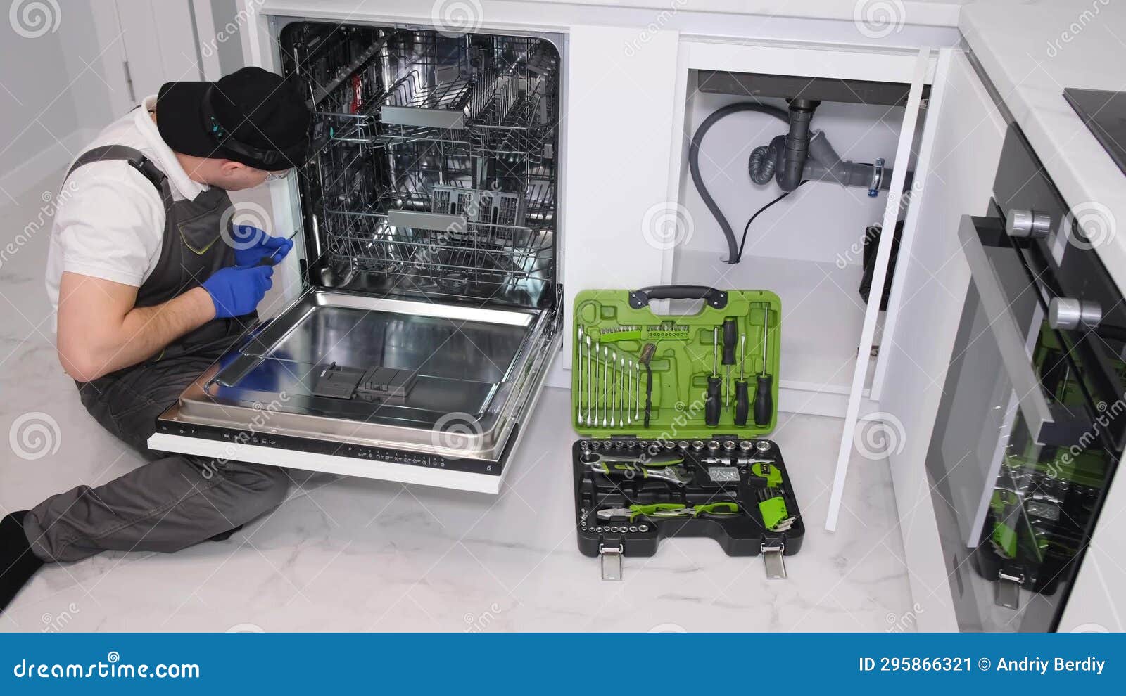 A Man Installs a New Dishwasher in the Kitchen Room Stock Image Image