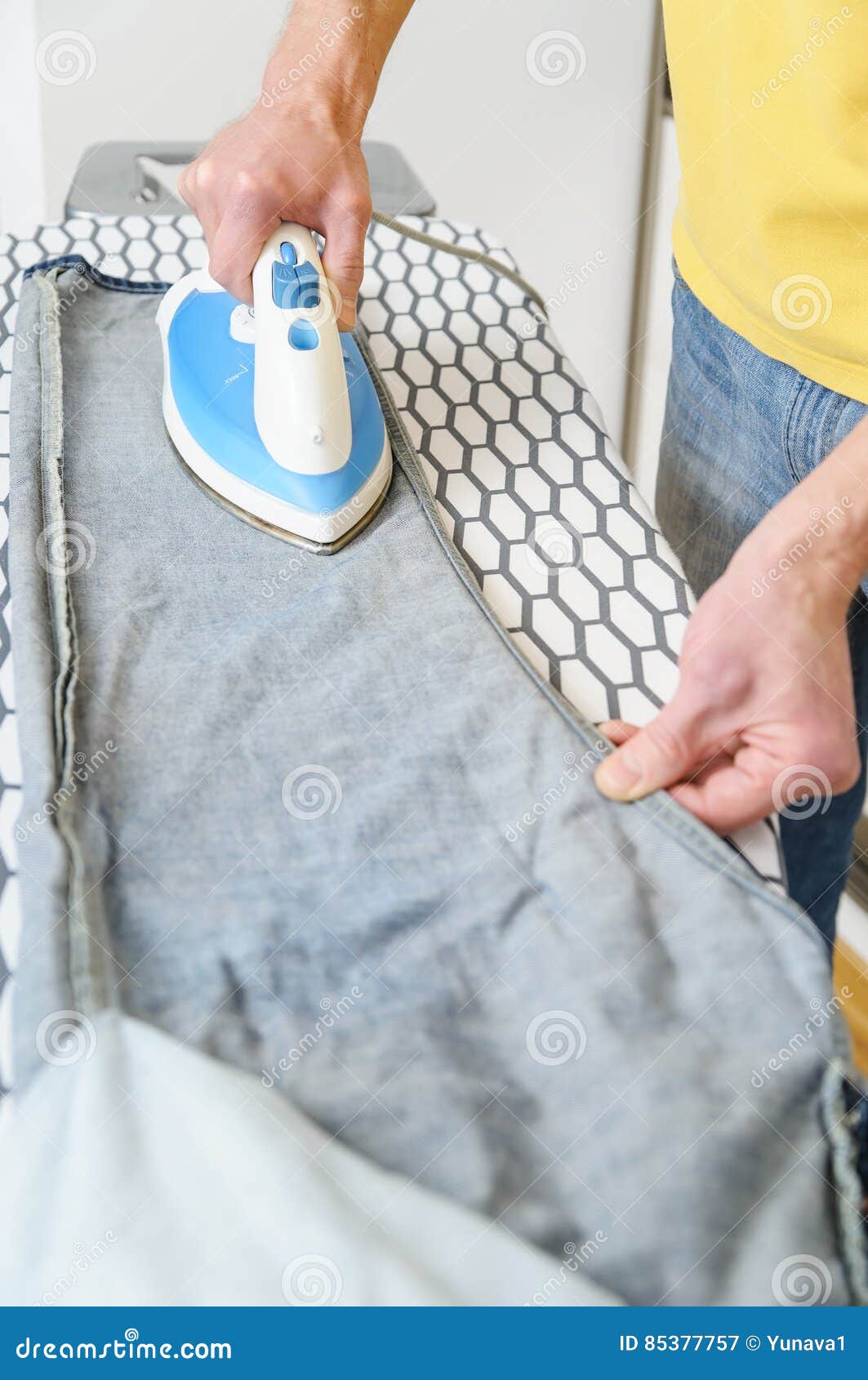 A man is ironing a jeans. stock image. Image of casual 85377757