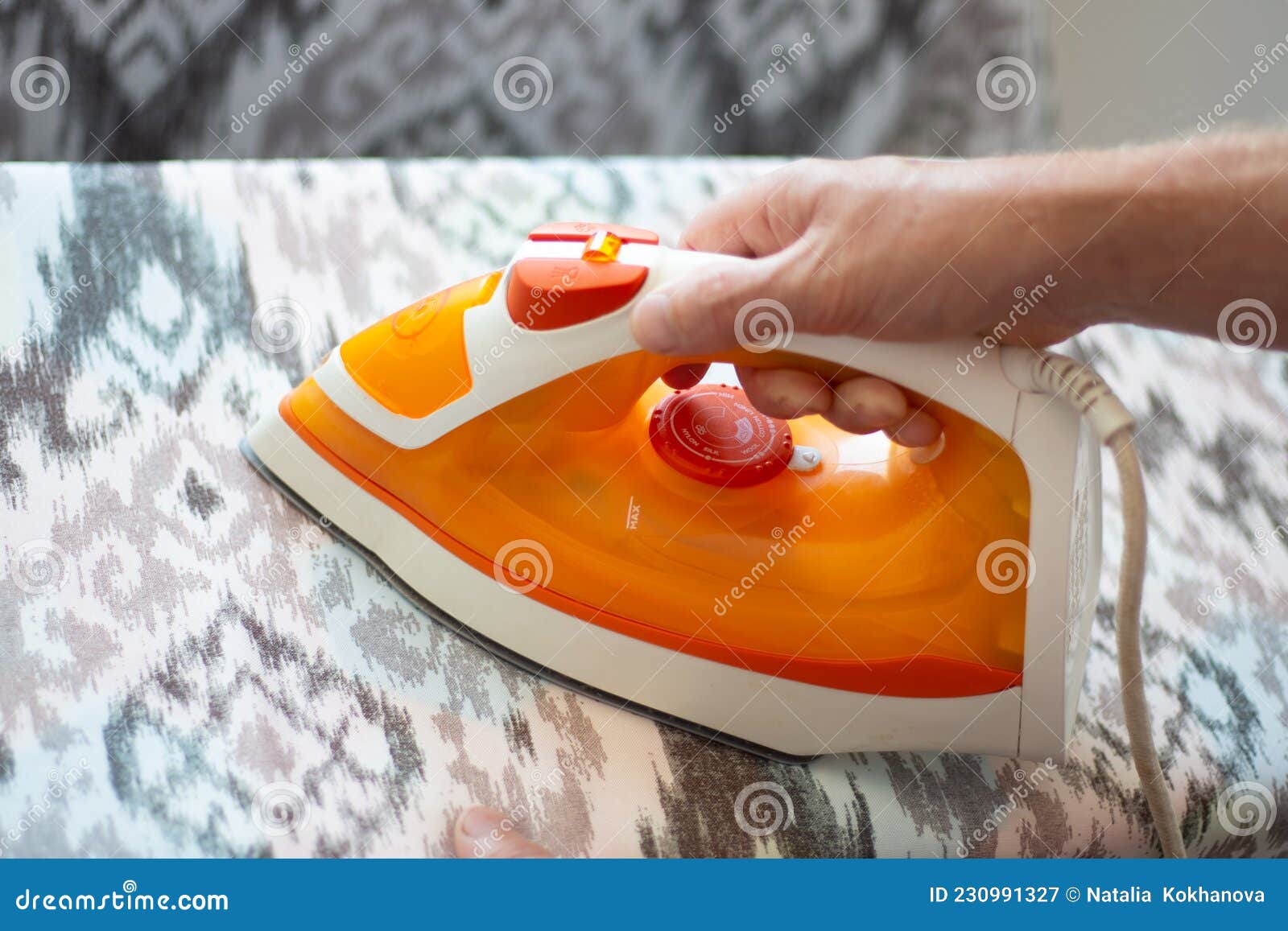 A Man Ironing Linen with an Electric Iron on an Ironing Board. Help