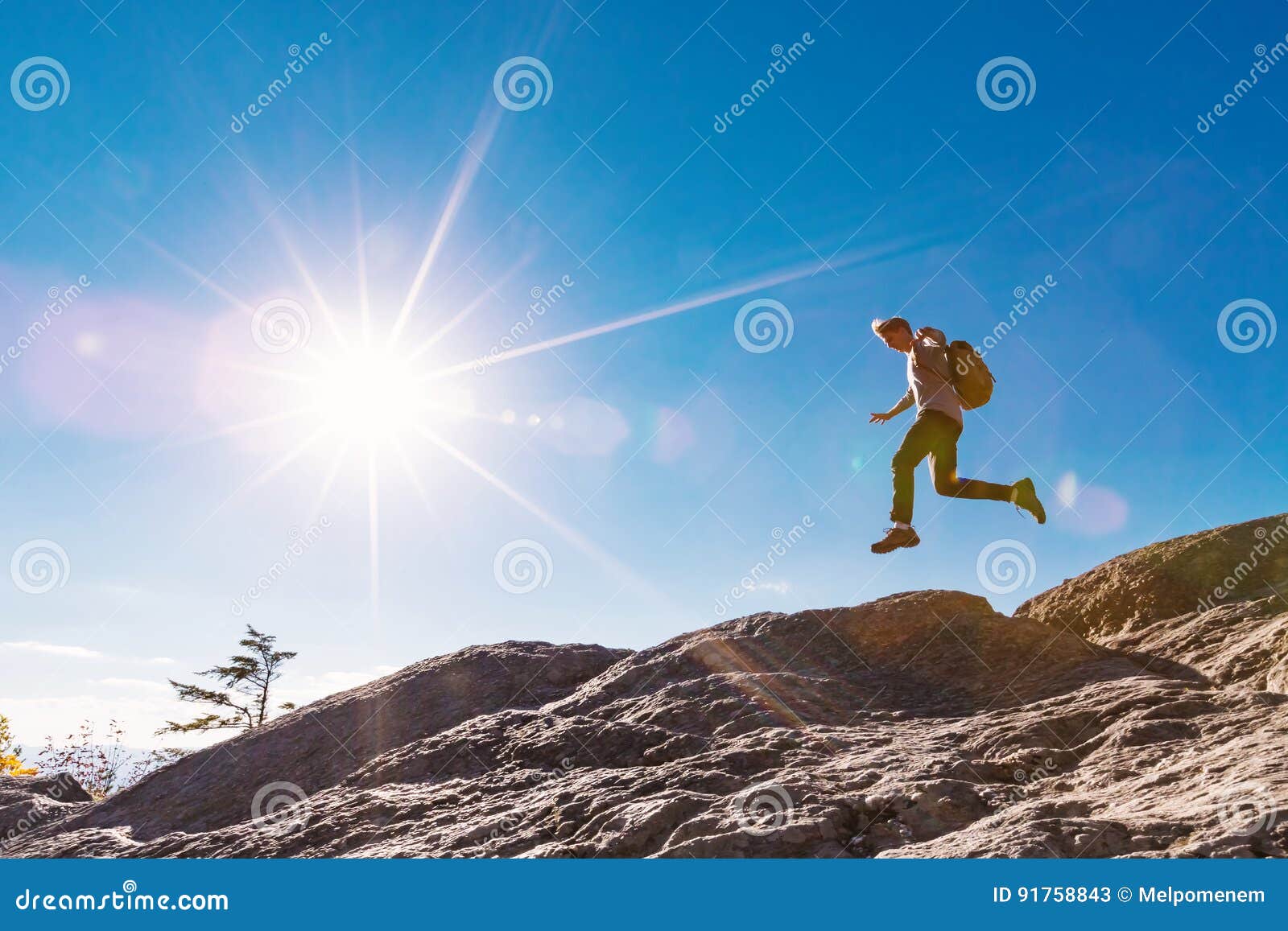 man jumping over gap on mountain hike