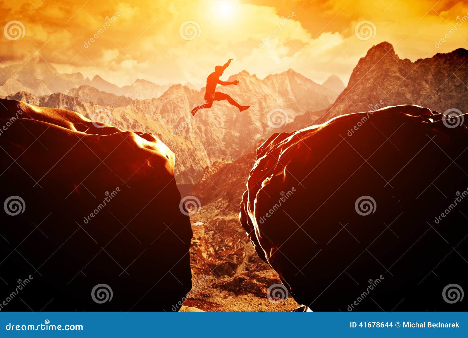 man jumping over precipice between two mountains