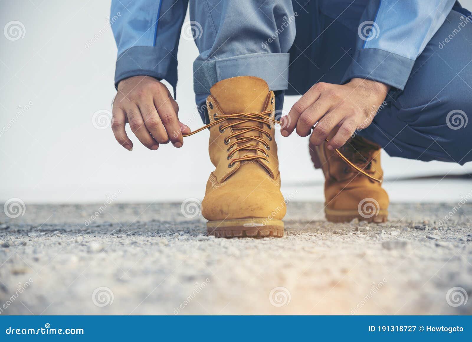 Man Kneel Down and Tie Shoes Industry Boots for Worker. Close Up Shot ...
