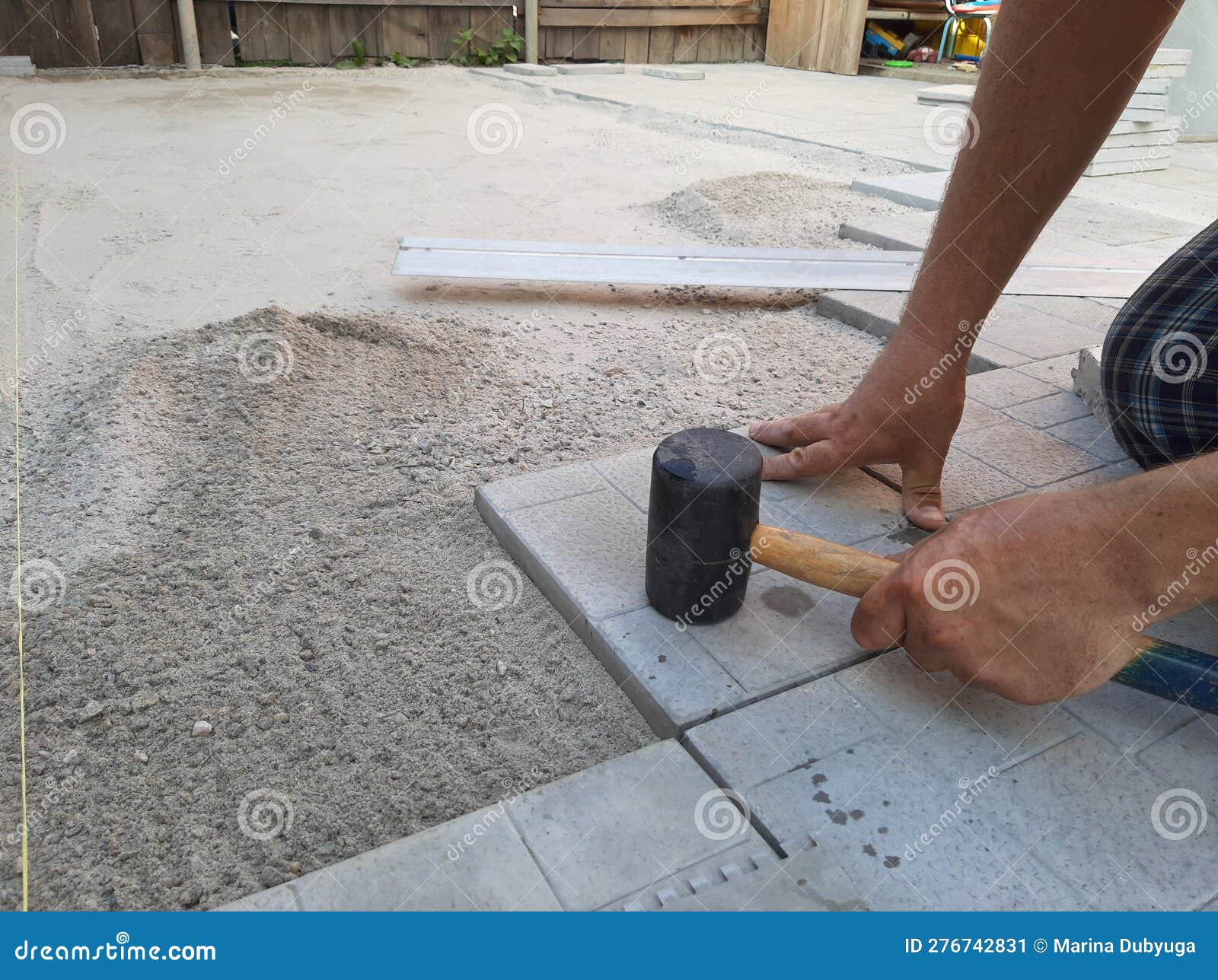 Laying of Tratuar Tiles. Hands of a Man in the Right Corner