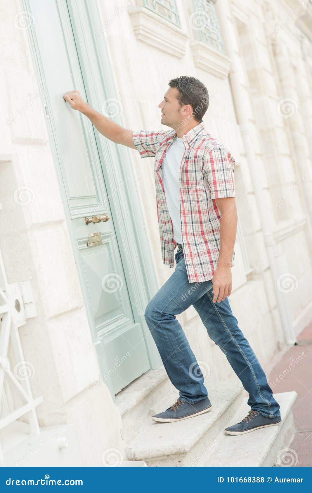 A Man Knocking On A Red Door With A Knocker RoyaltyFree Stock Photo