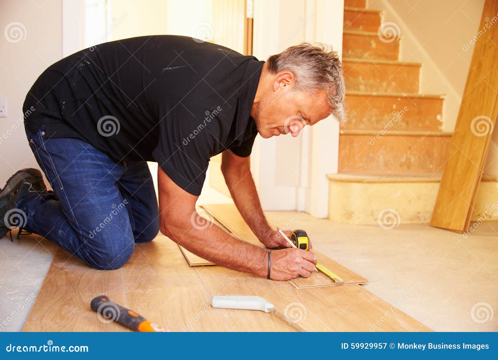Man Laying Wood Panel Flooring during a House Refurbishment Stock Image