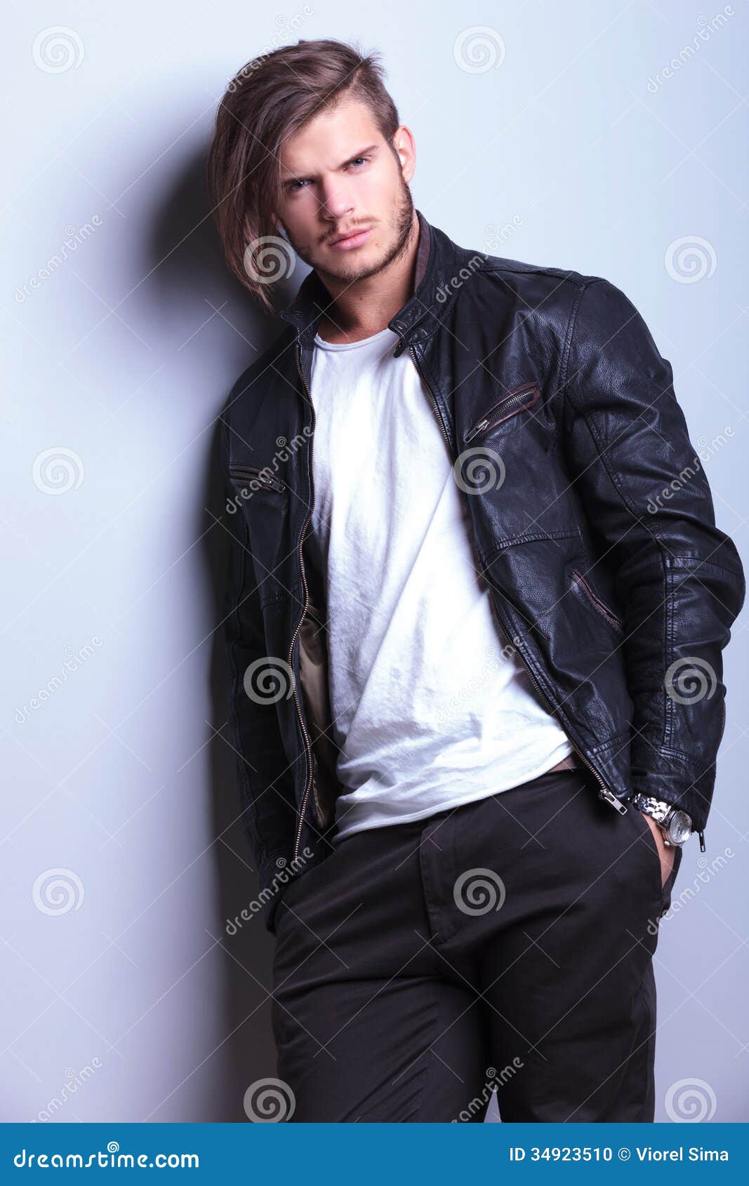 Man in Leather Jacket Leaning Against a Gray Wall Stock Photo - Image ...