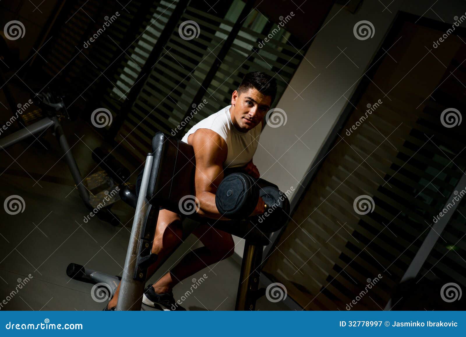 Man lifting dumbell in gym stock image. Image of male 32778997
