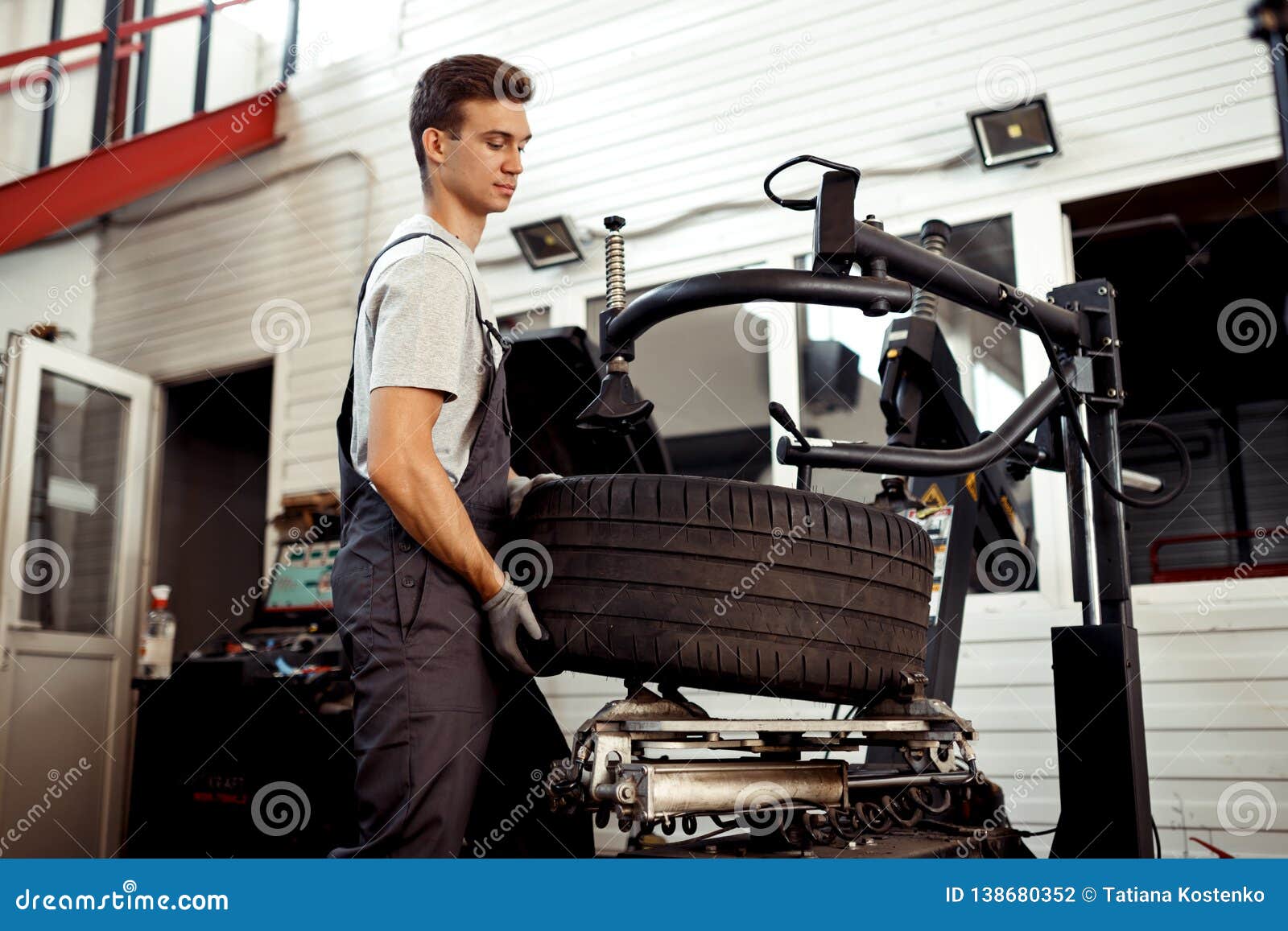 A Man is Lifting a Tire while at Work Stock Photo Image of diagnosis, check 138680352