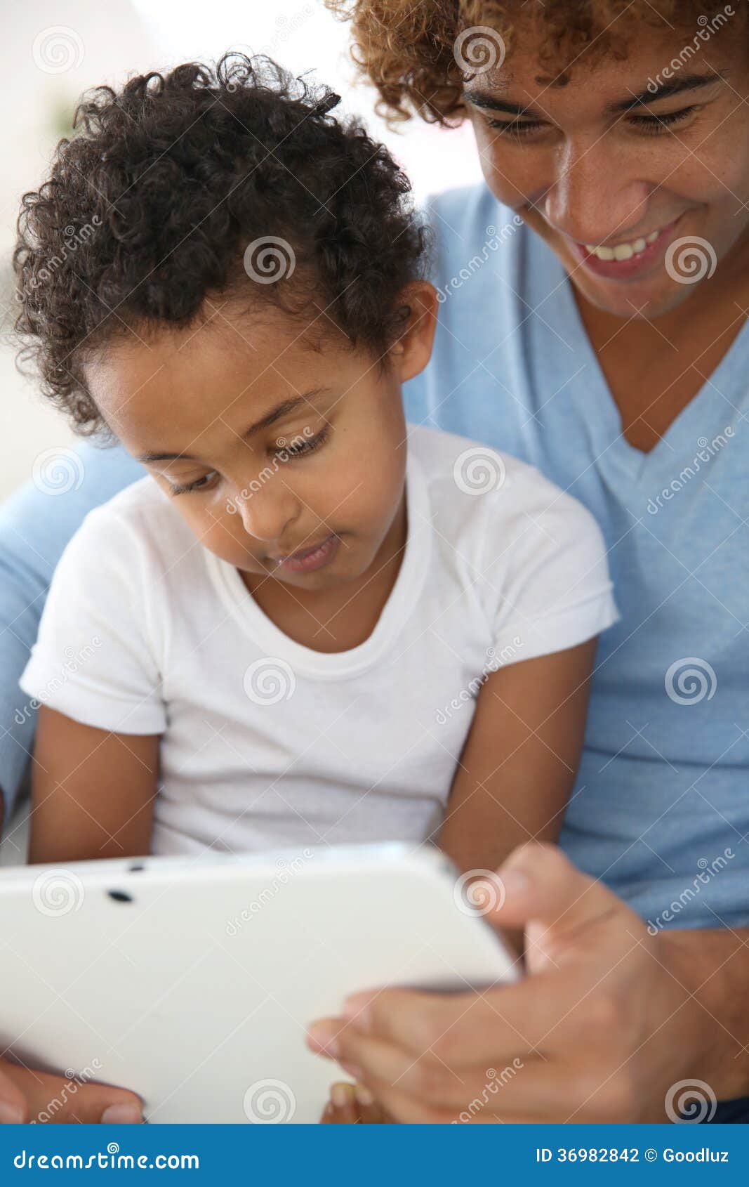 man with little boy using tablet