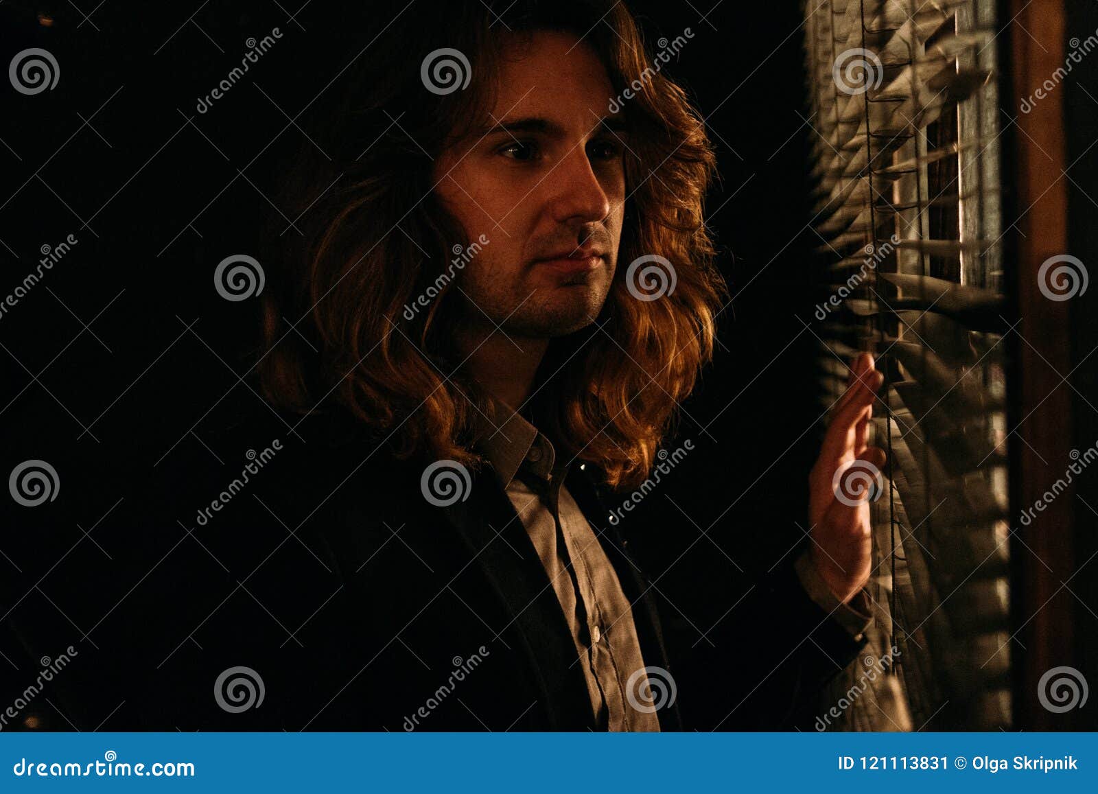 A Man with Long Hair is Standing Near the Window, Opening the Blinds with Lobes, in a Black Jacket. Look at the Street, Spy on Peo Stock Image - Image of fashion, A Man with Long Hair is Standing Near the Window, Opening the Blinds with Lobes, in a Black Jacket. Look at the Street, Spy on Peo Stock Image - Image of fashion,