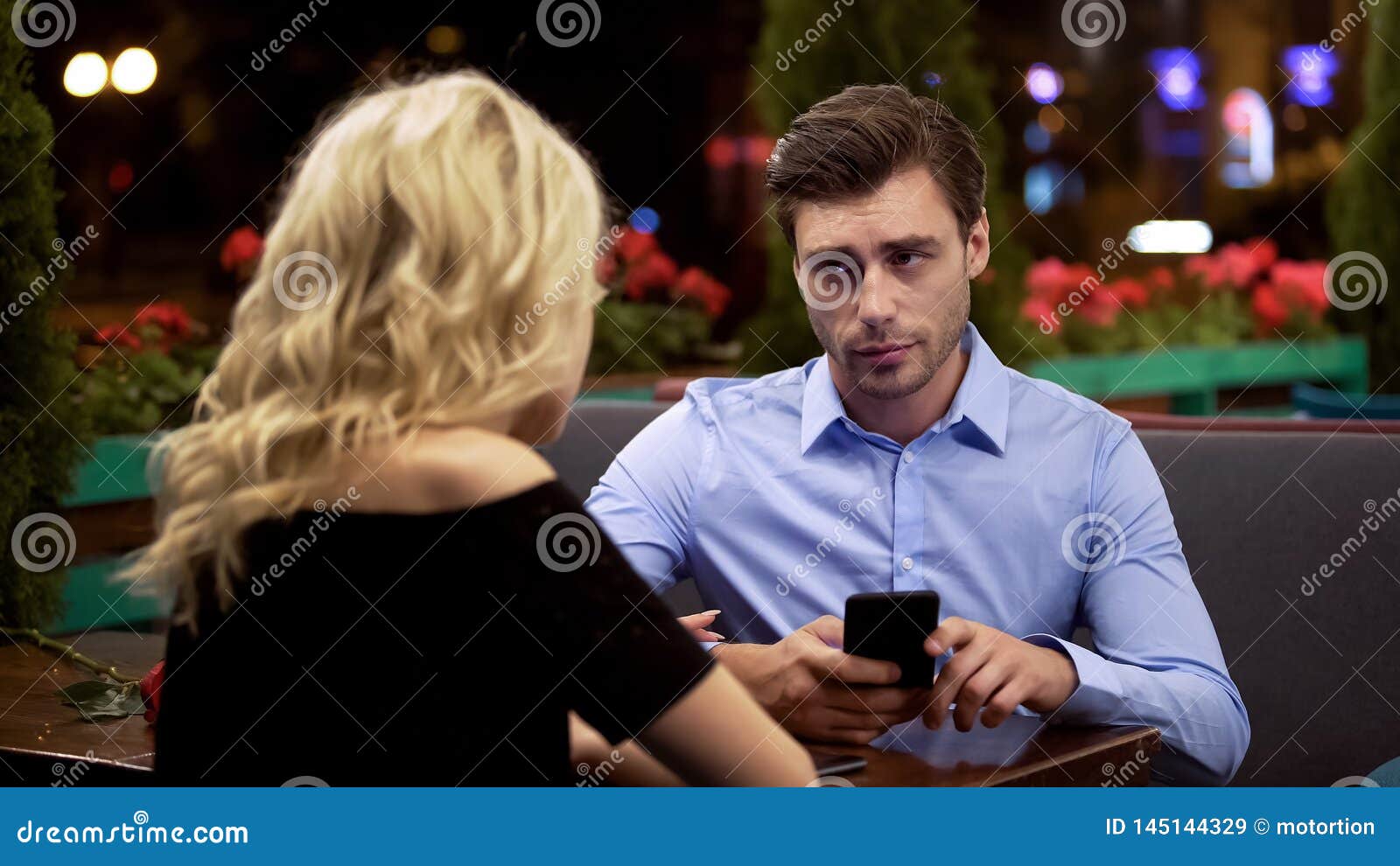 man looking with annoyance on girlfriend who stopping him surfing net, addiction