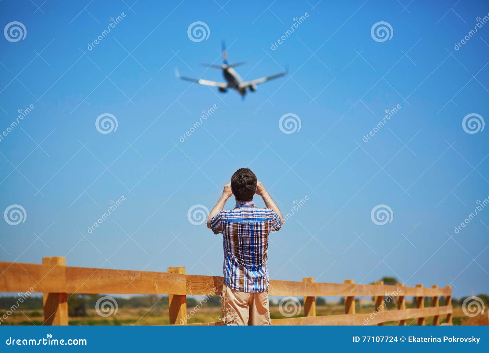man is looking at the glide path and landing plane