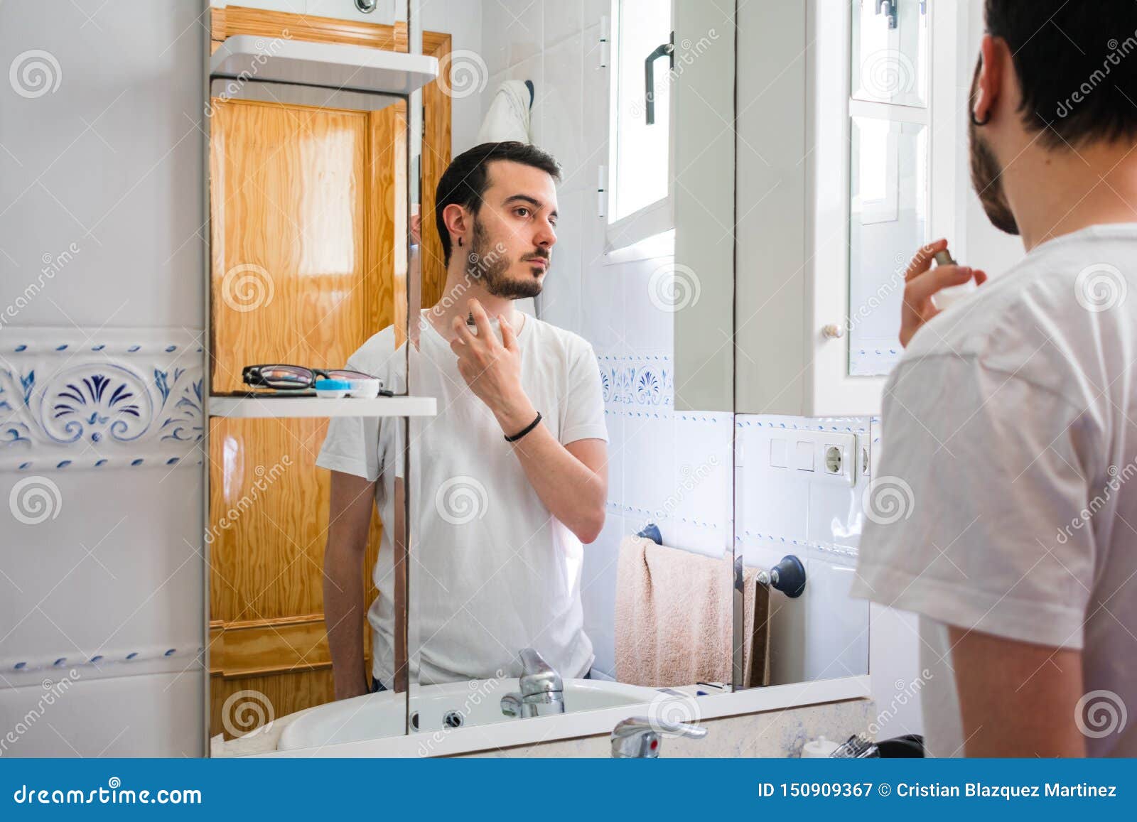 Man Looking At Himself In A Mirror In The Bathroom He Is Brushing His 