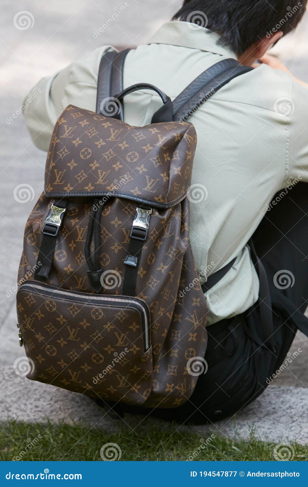 Man with Louis Vuitton Brown Backpack before Giorgio Armani