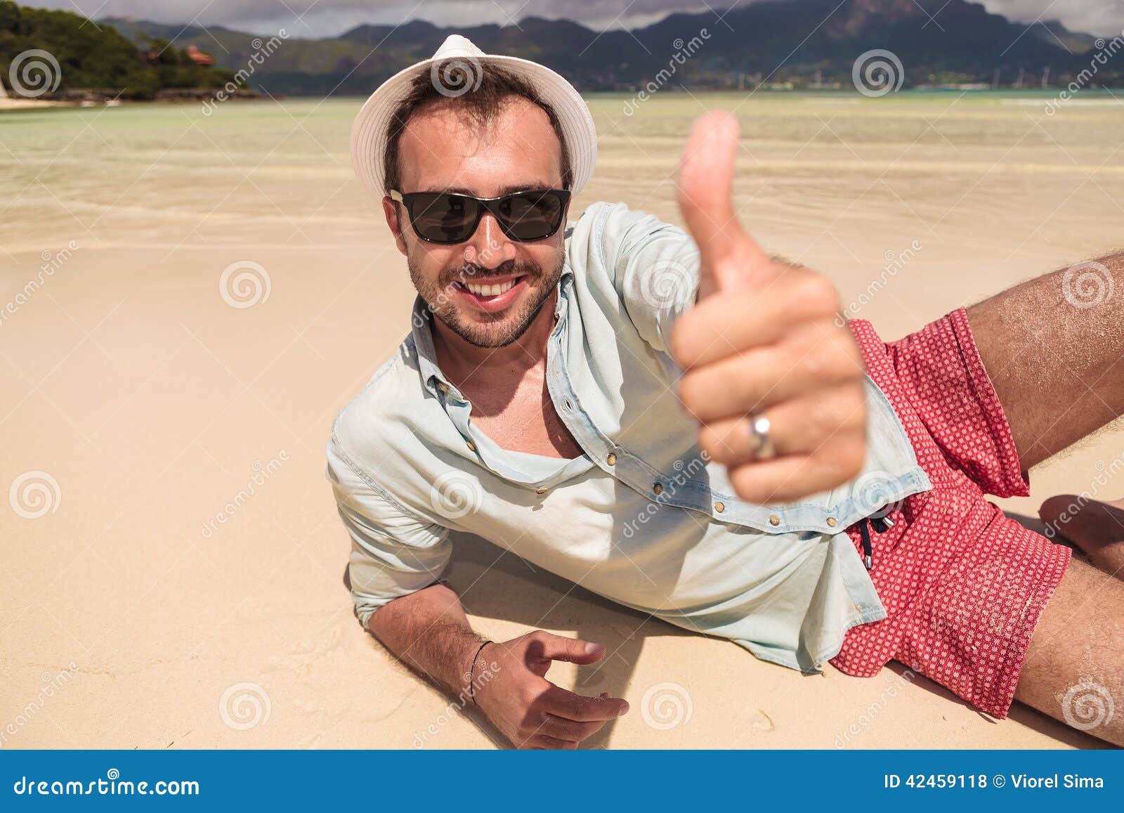 Man Lying on Beach and Makes the Ok Sign Stock Photo - Image of smile ...