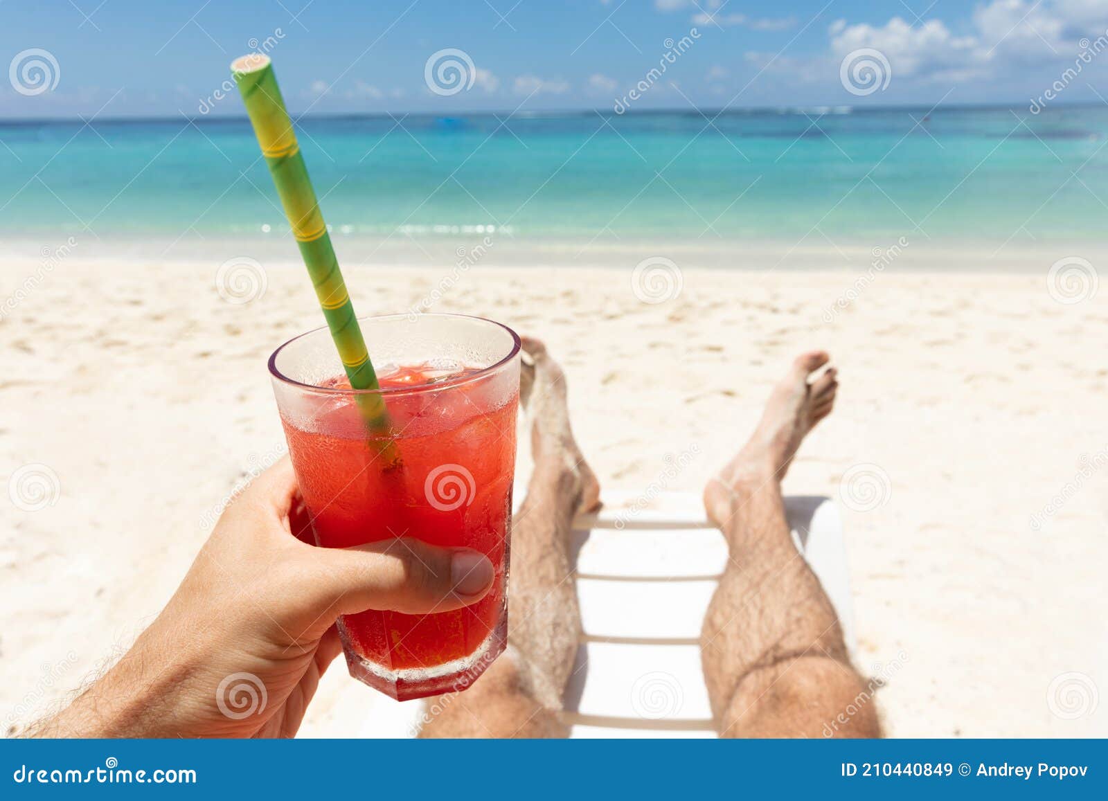 Man Lying on Deck Chair Holding Juice Glass at Beach Stock Image ...