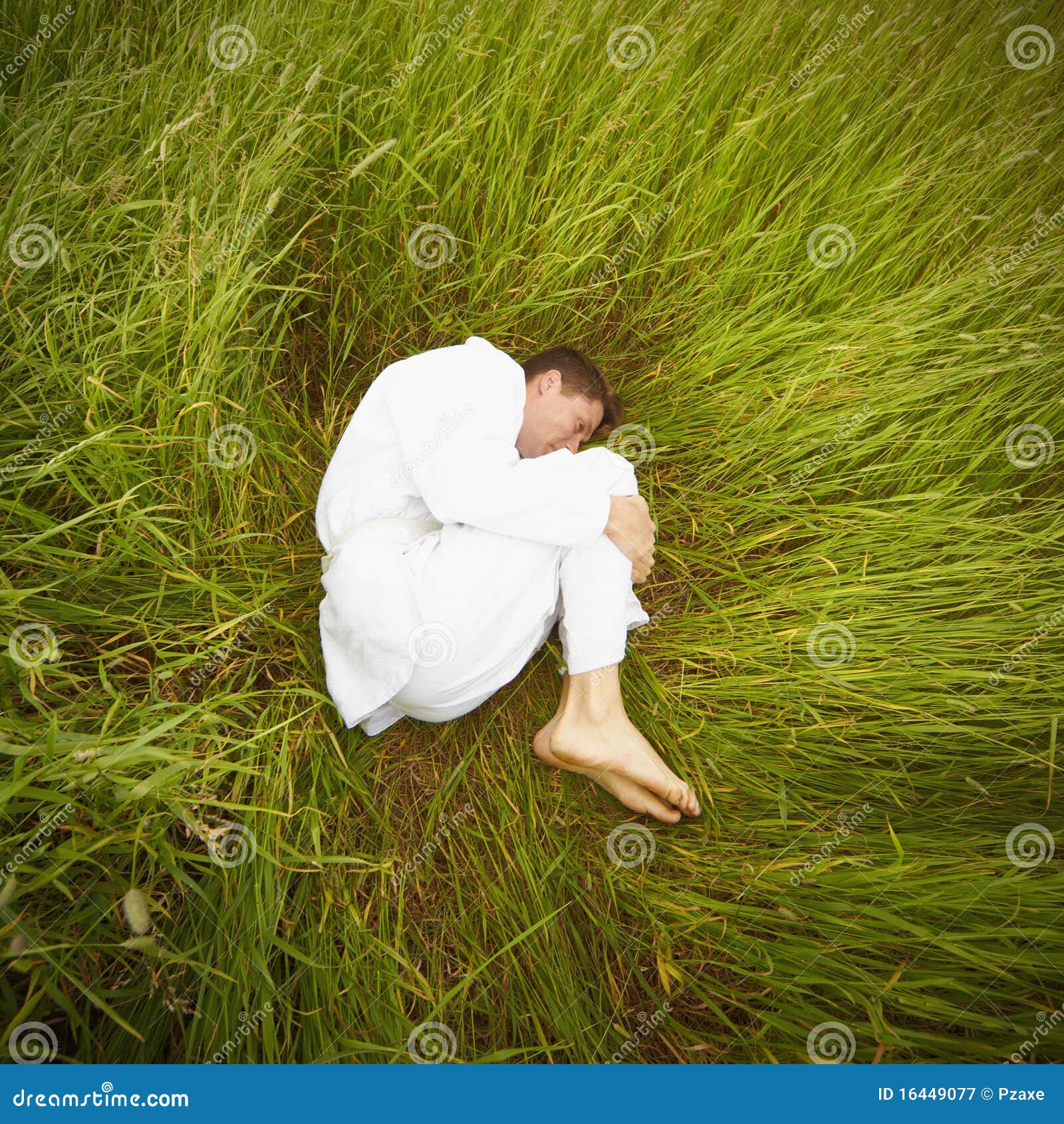 Man Lying On Grass In Fetal Position Royalty Free Stock Photography