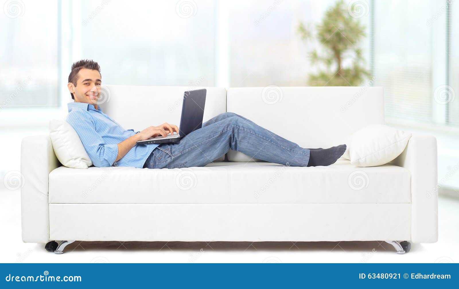 A Man Lying On The Sofa Working Stock Image Image Of Classy Room