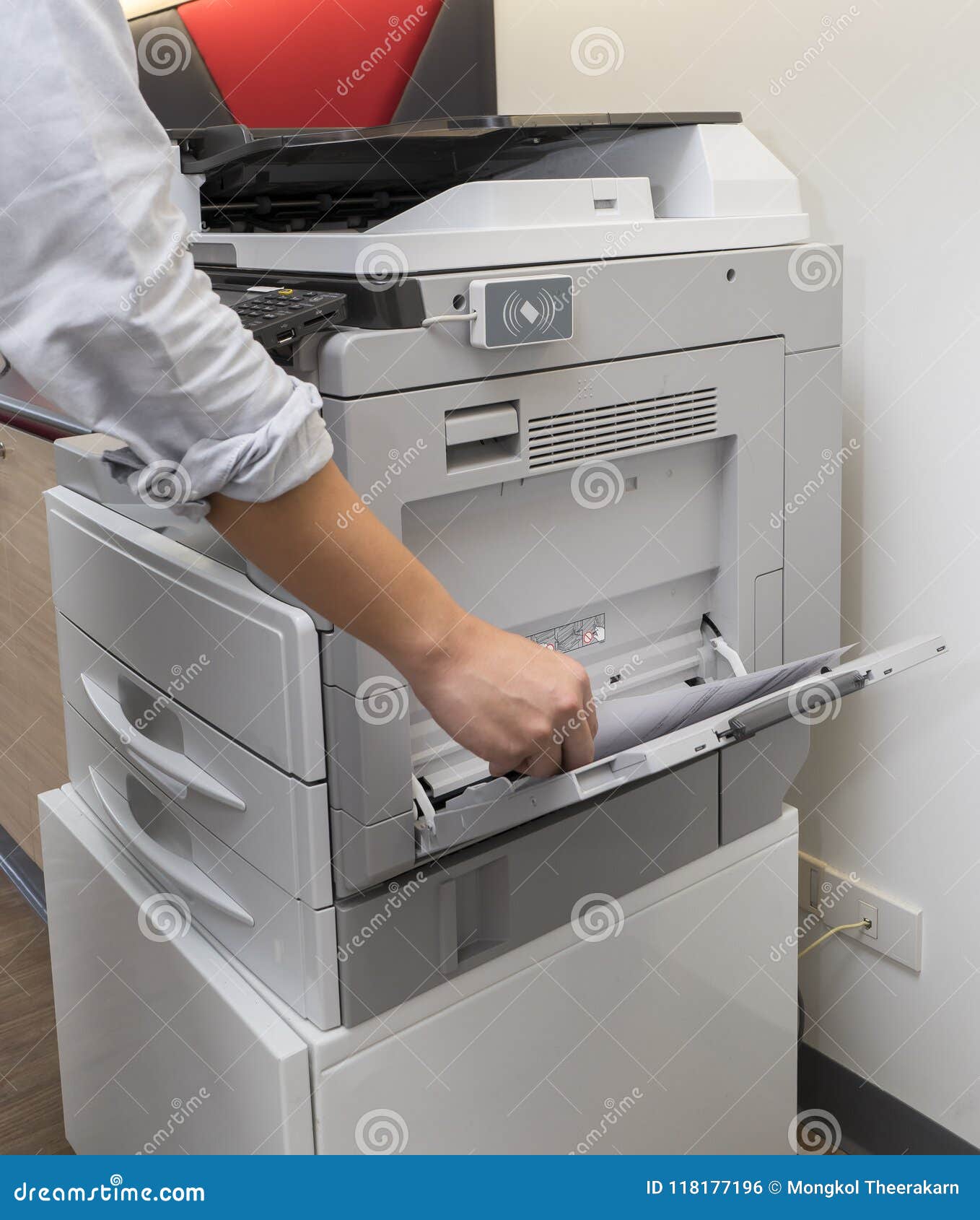 man making photocopy of document on a photocopier machine with access control for key card.