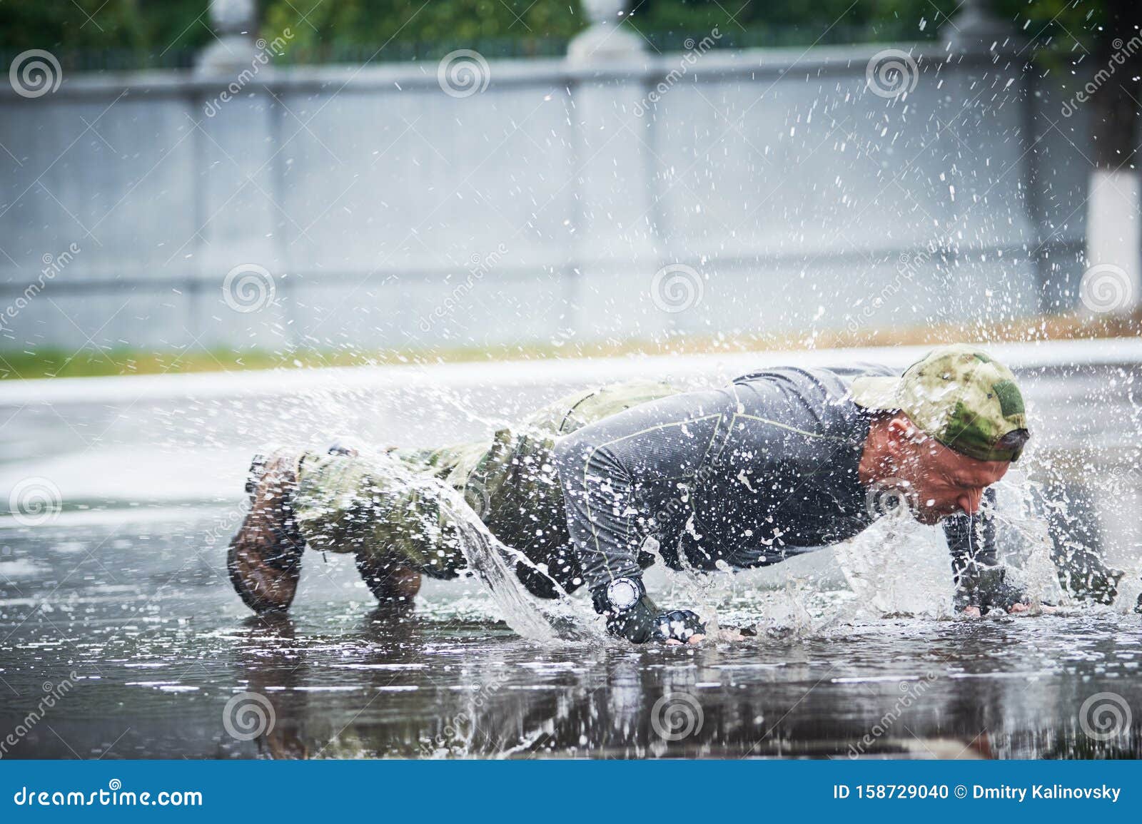 Outdoors Training. Man Doing Push Up on Wet Place in Military