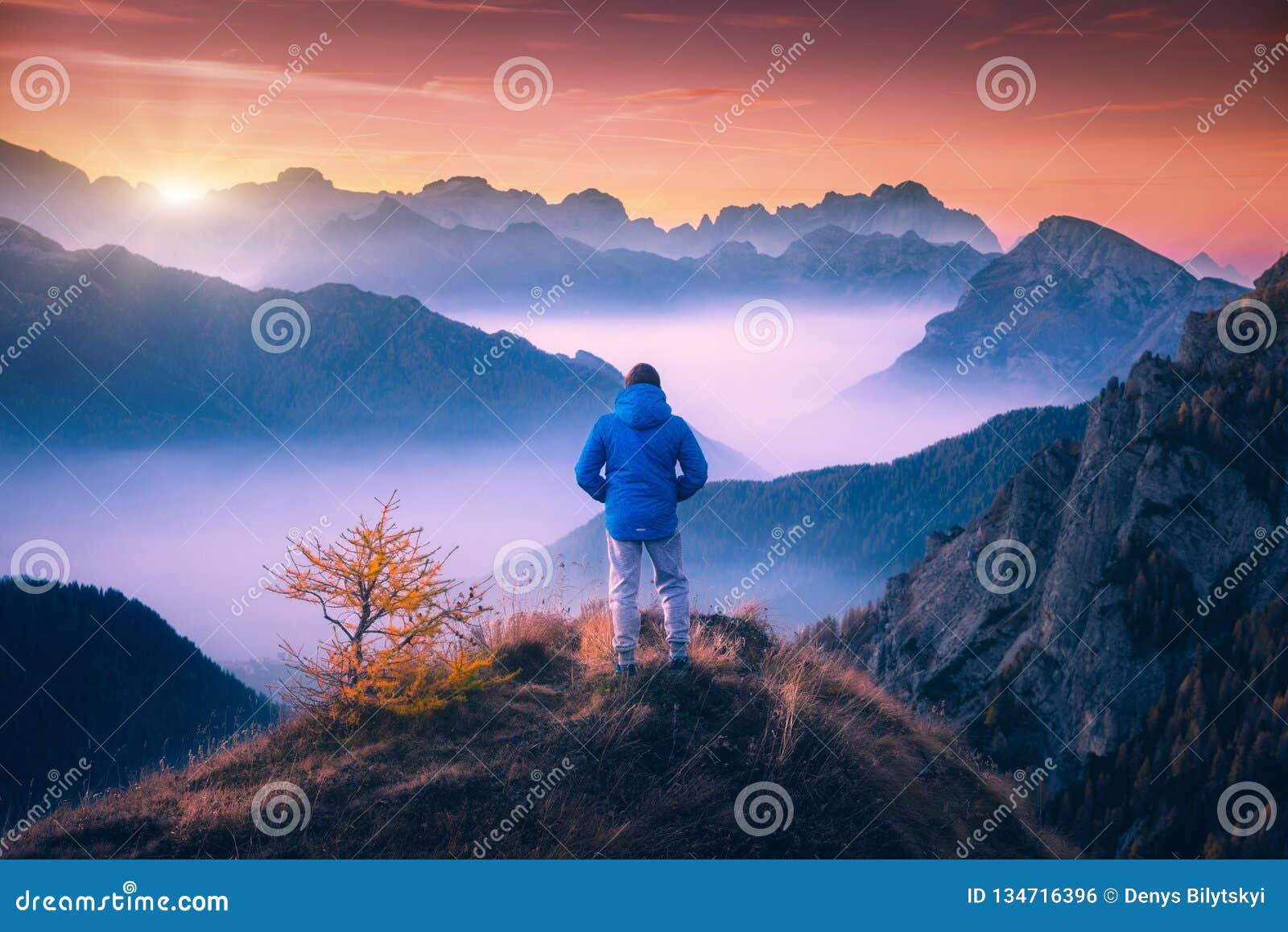 man on the mountain peak looking on mountain valley