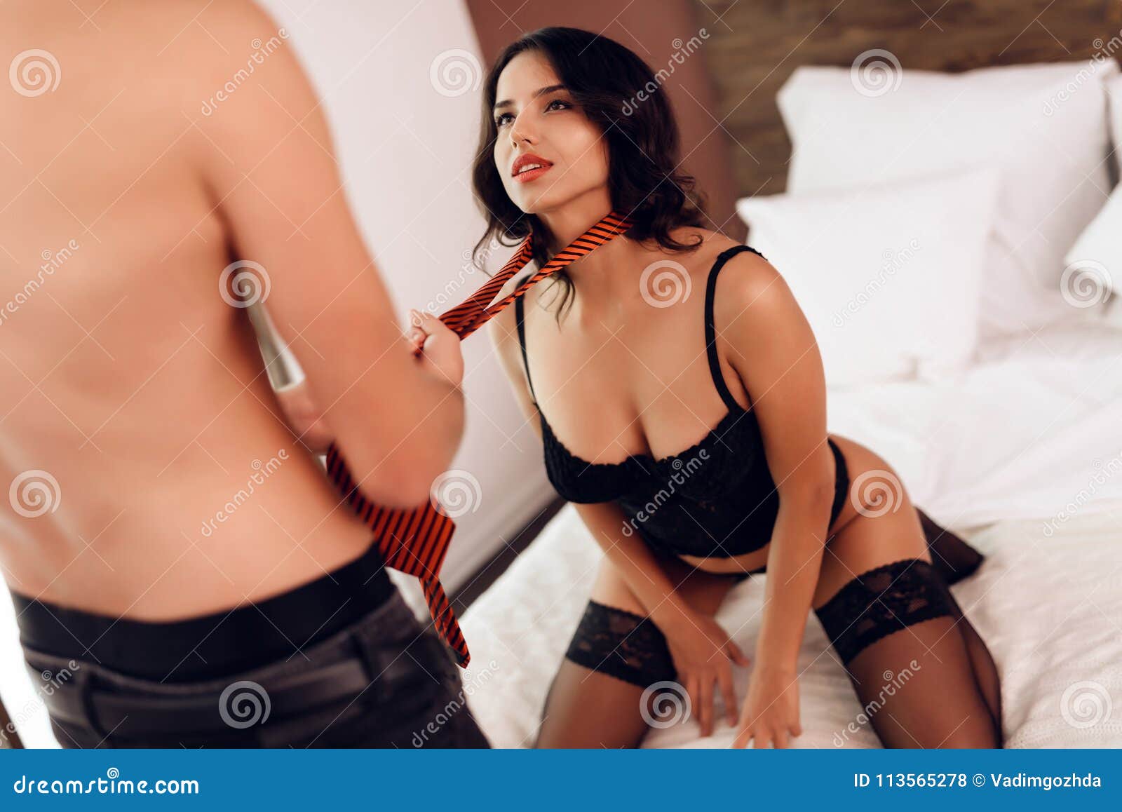 Man with Naked Torso Ties Passionate Brunette in Lingerie while in Bedroom