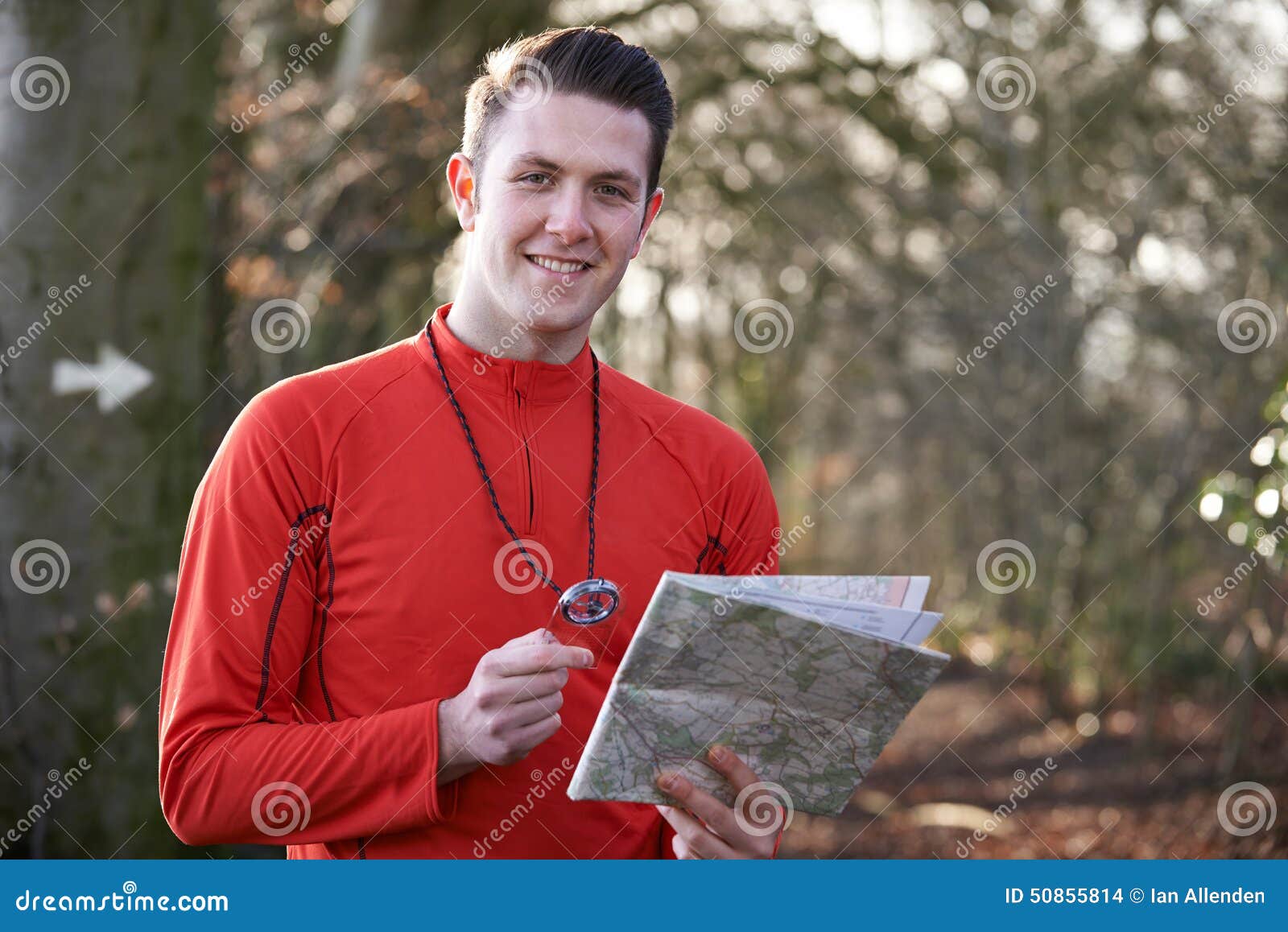 man orienteering in woodlands with map and compass