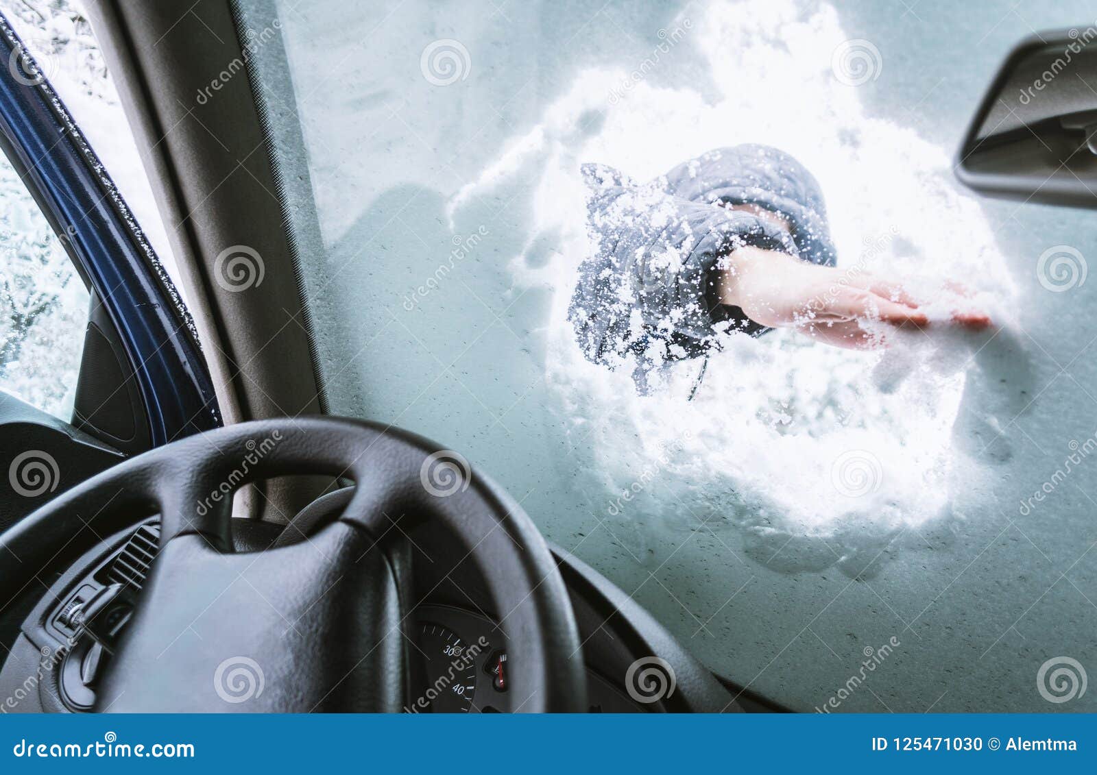 Man Cleaning Snow on His Car Windows Glass.View from Inside of C