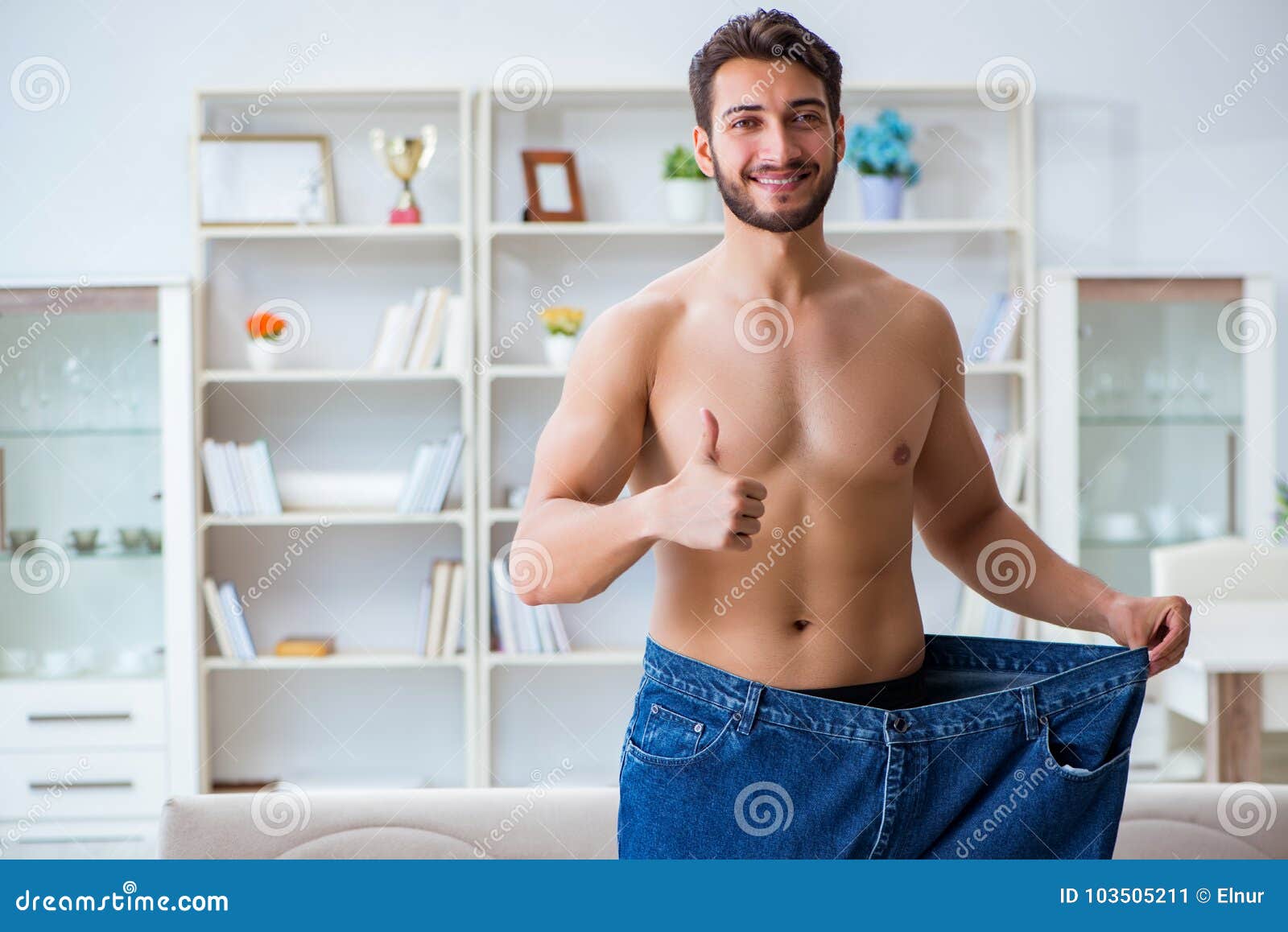 surprised overweight man holding oversize pants after weight loss on white  Stock Photo - Alamy