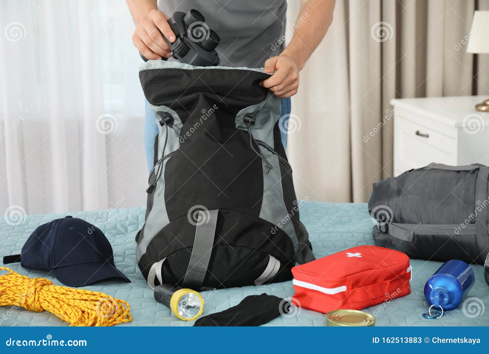 Man Packing Different Camping Equipment into Backpack at Home Stock ...