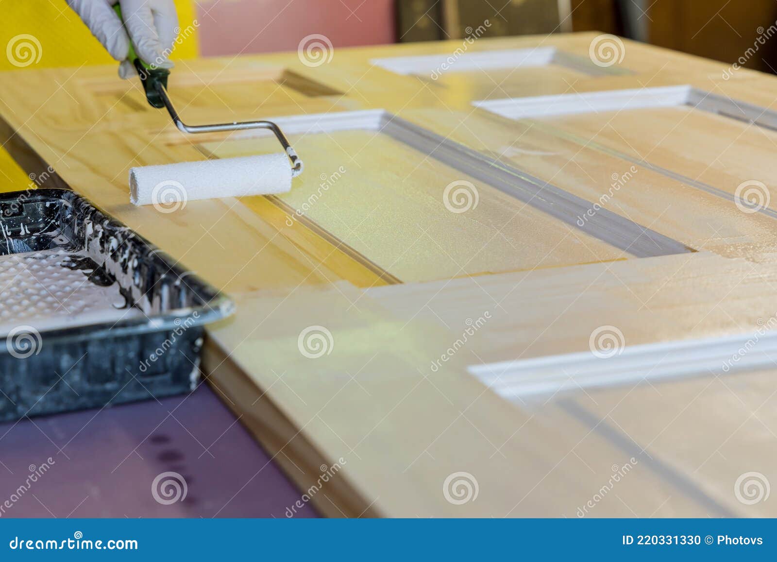 Man Painting a Wooden Door Using Paint Roller with Carpenter Working