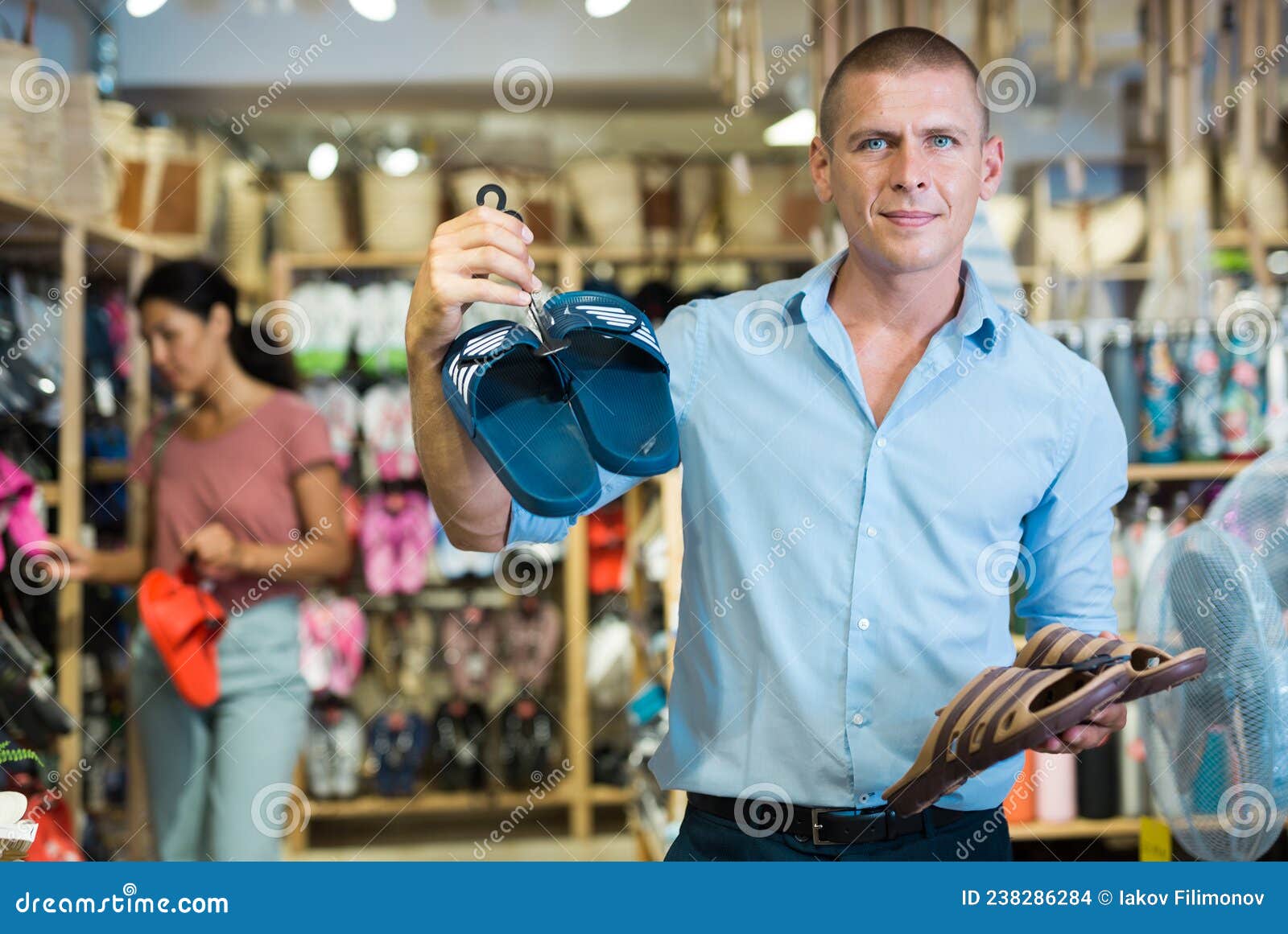 man with pairs of jandals in store