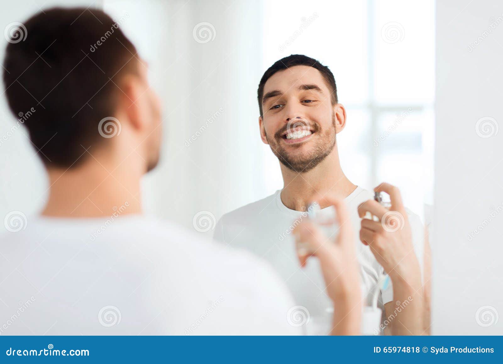 Man With Perfume Looking To Mirror At Bathroom Stock Photo ...
