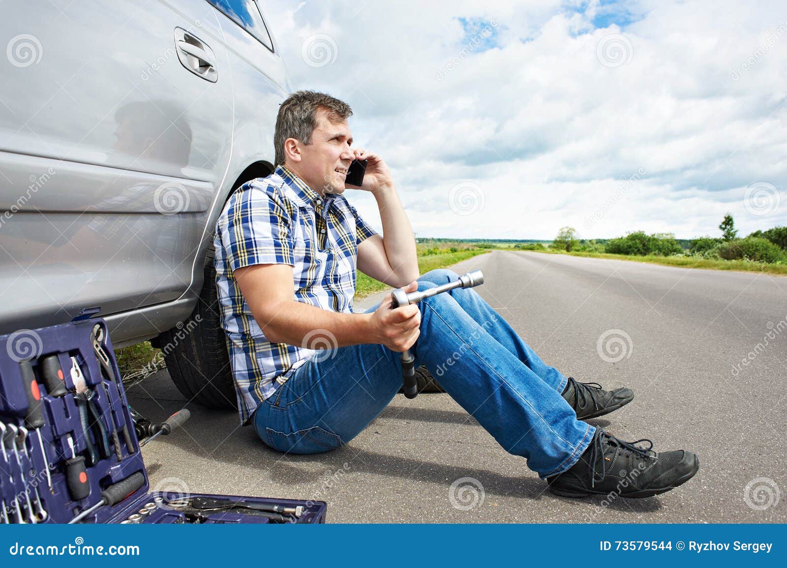 Man with Phone is Calling in Service of Spare Tire Car Stock Photo