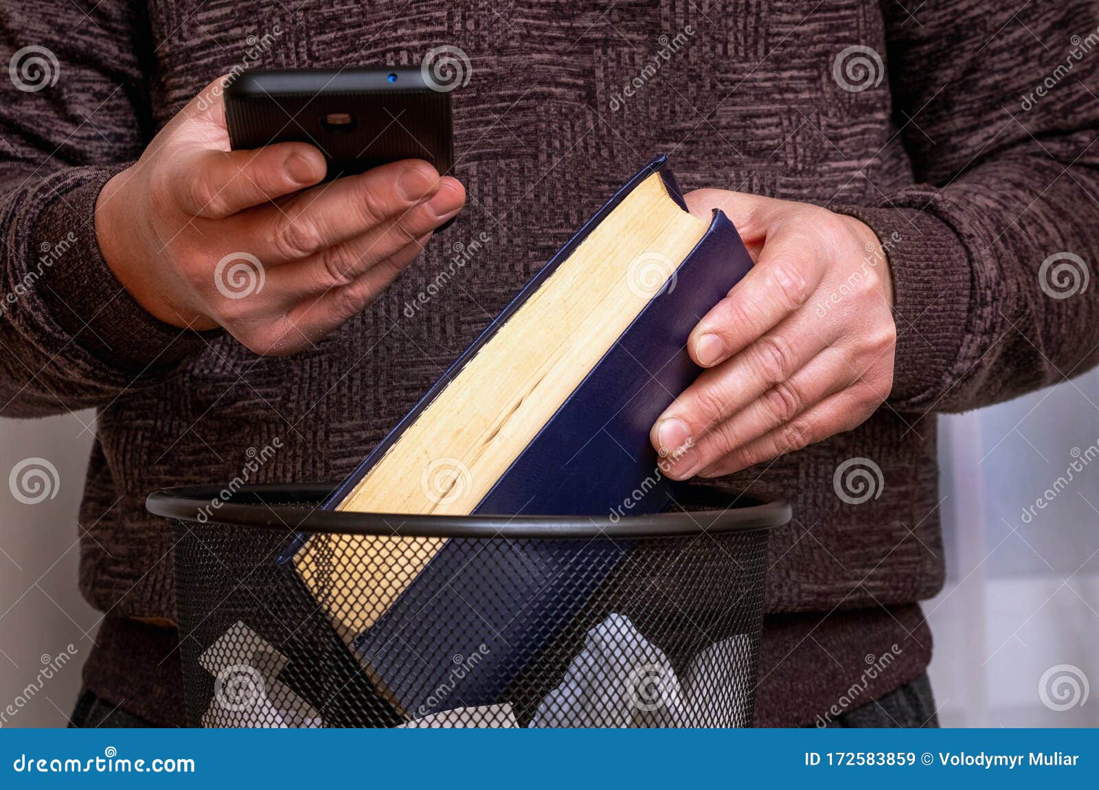 A Man with a Phone in His Hand Throws a Book in the Trash. an Ebook
