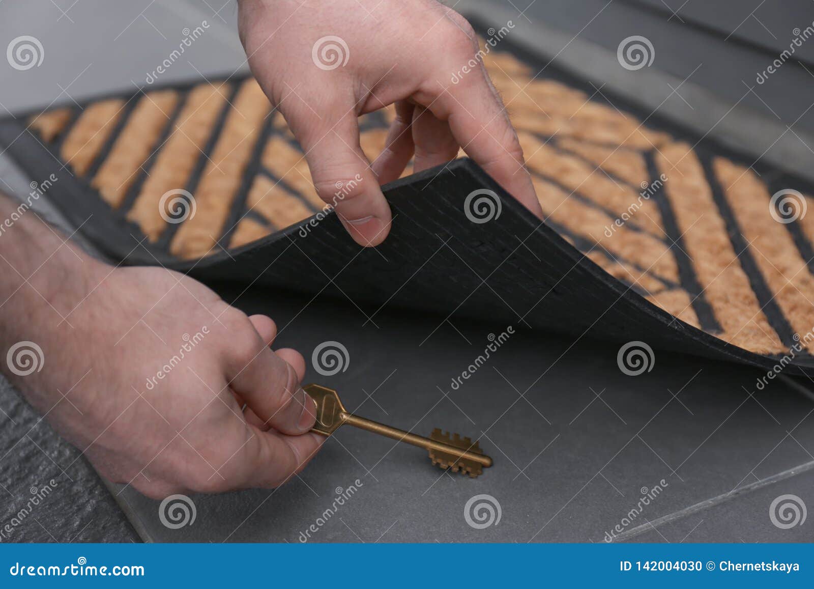 Man Picking Up Key Hidden Under Door Mat Stock Photo Image Of