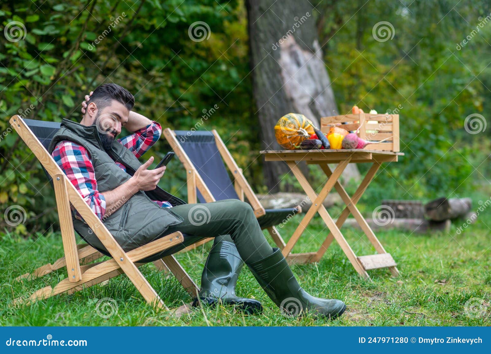 A Man in Plaid Shirt and Vest Sitting in the Yard Stock Photo - Image ...