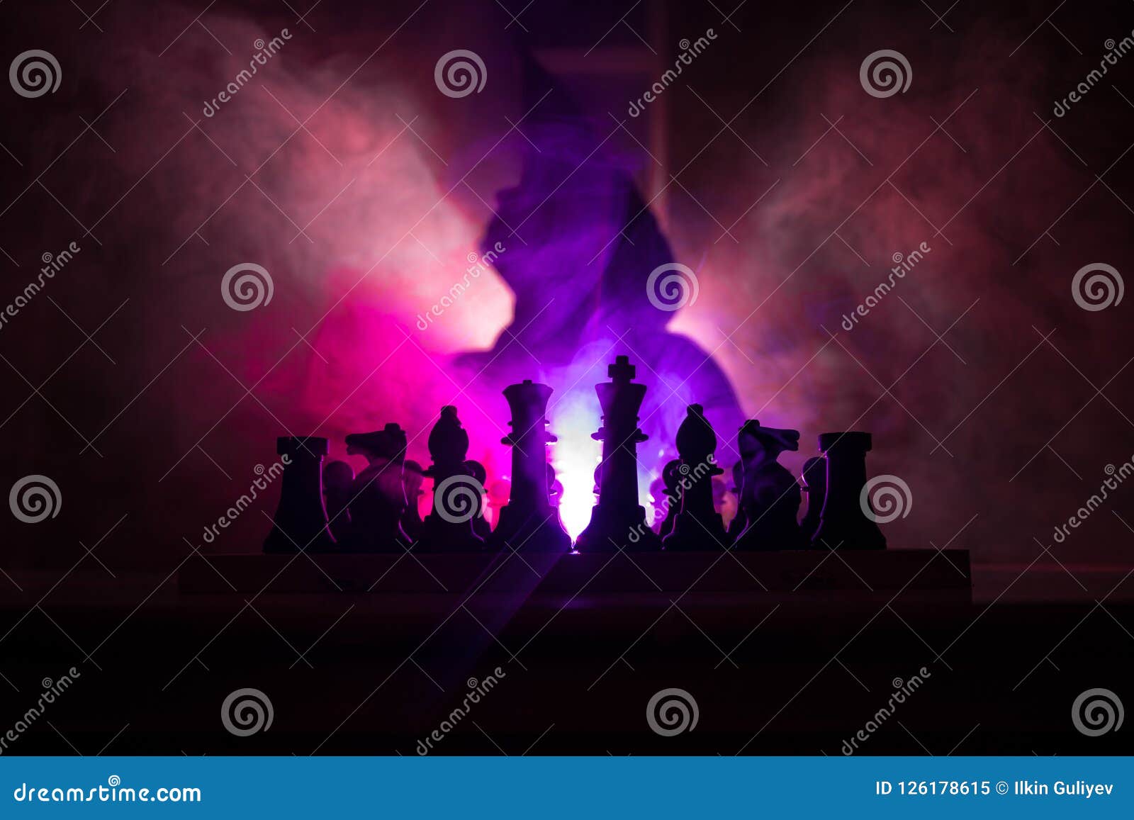 man playing chess. scary blurred silhouette of a person at the chessboard with chess figures. dark toned foggy background.