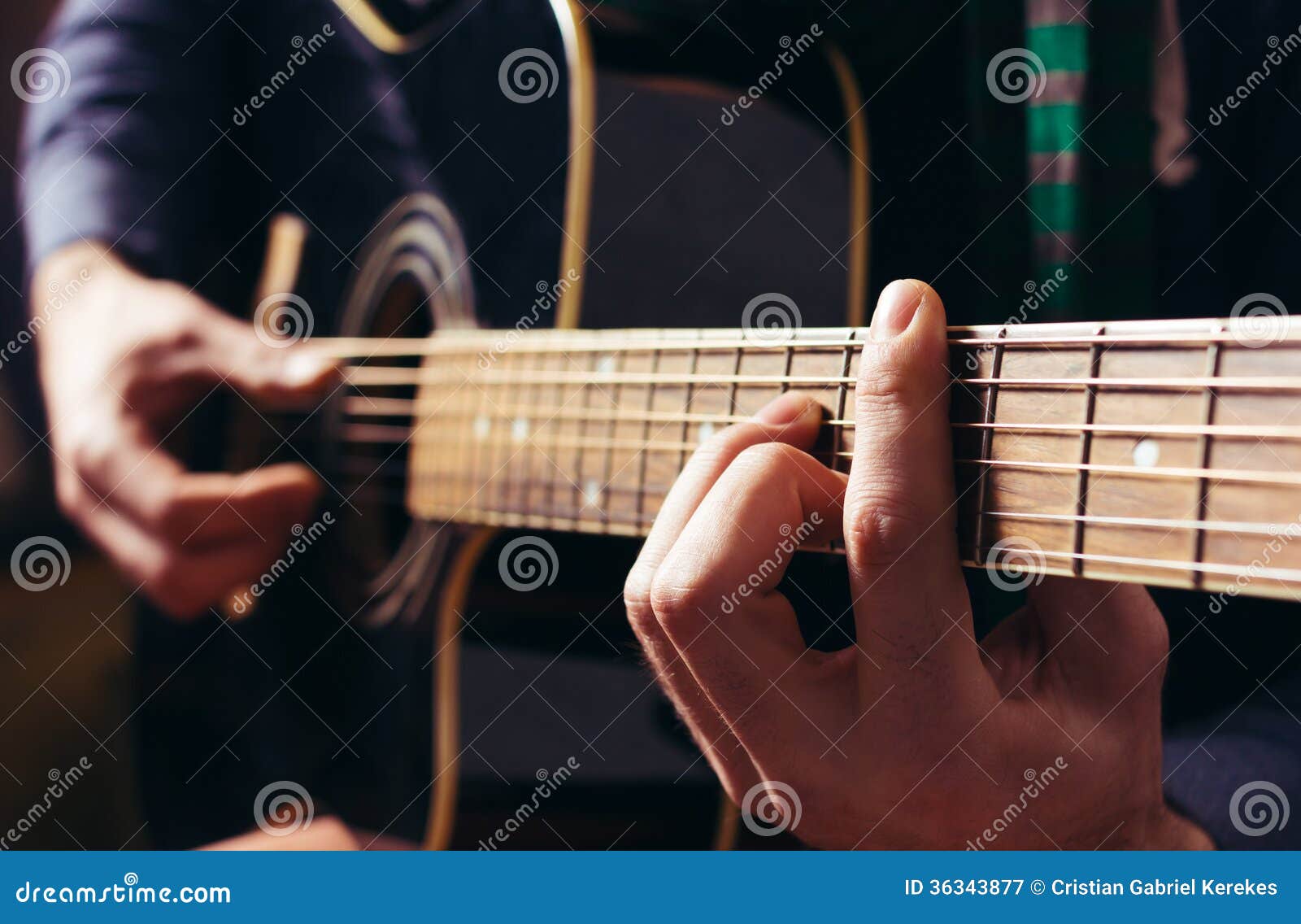 man playing music at black wooden acoustic guitar