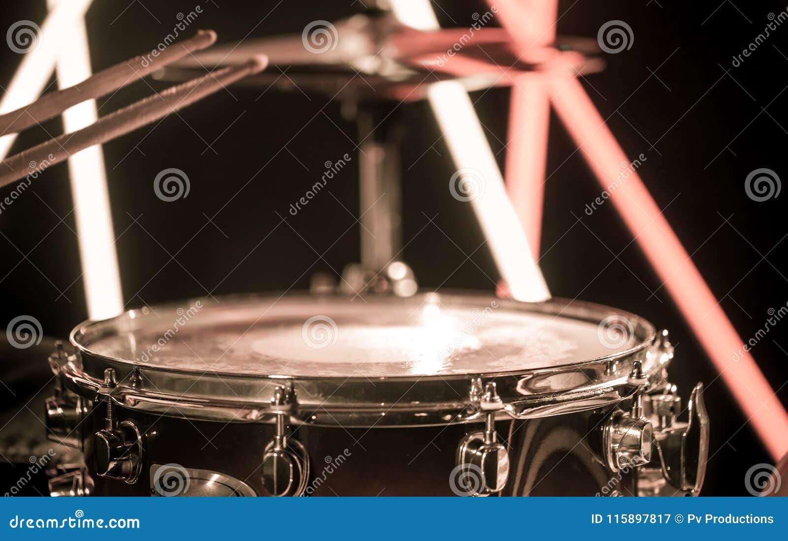 a man plays with sticks on a musical percussion instrument, close-up. on a blurred background of colored lights.