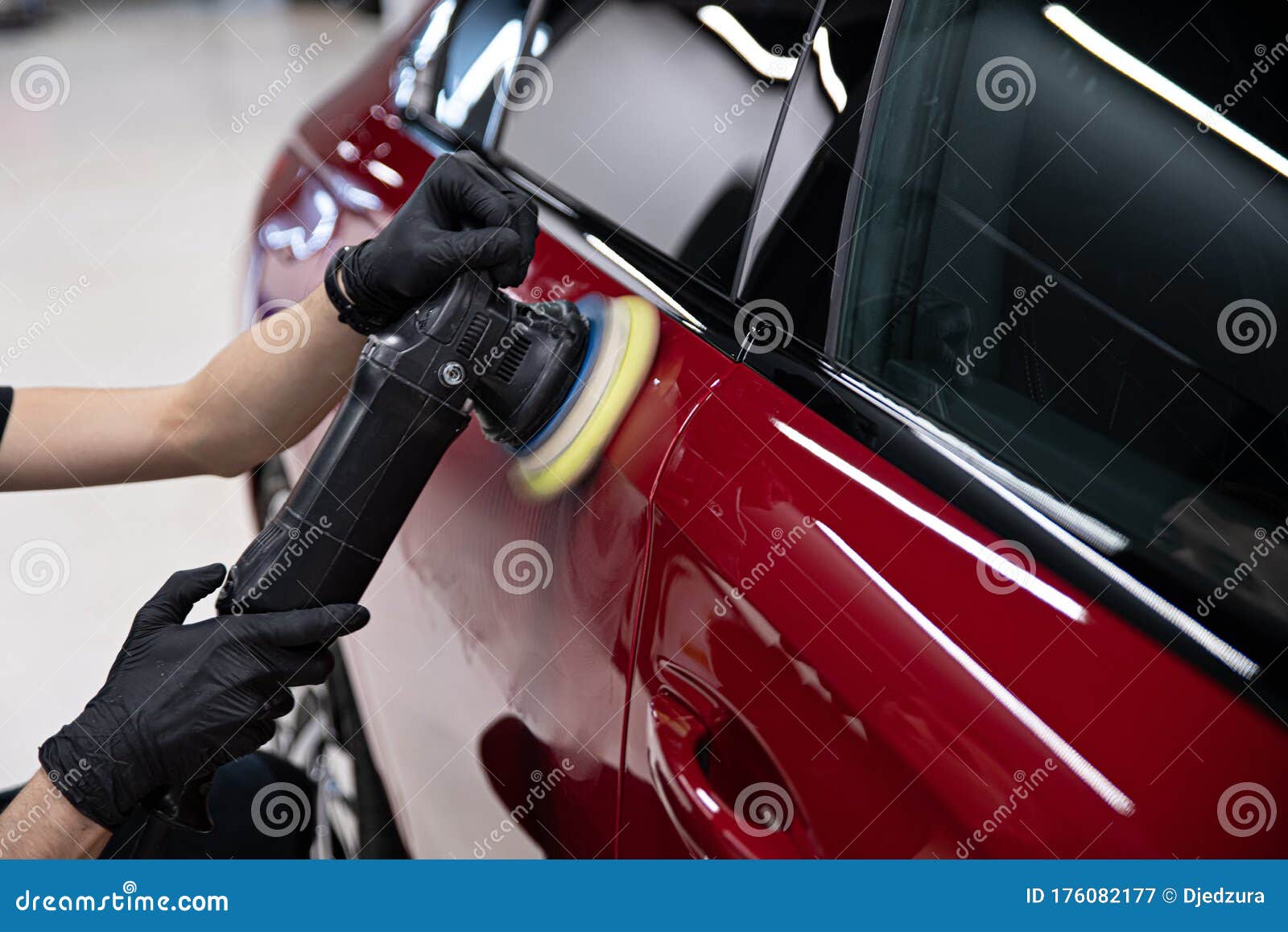 man polishing car paint varnish in detailing studio