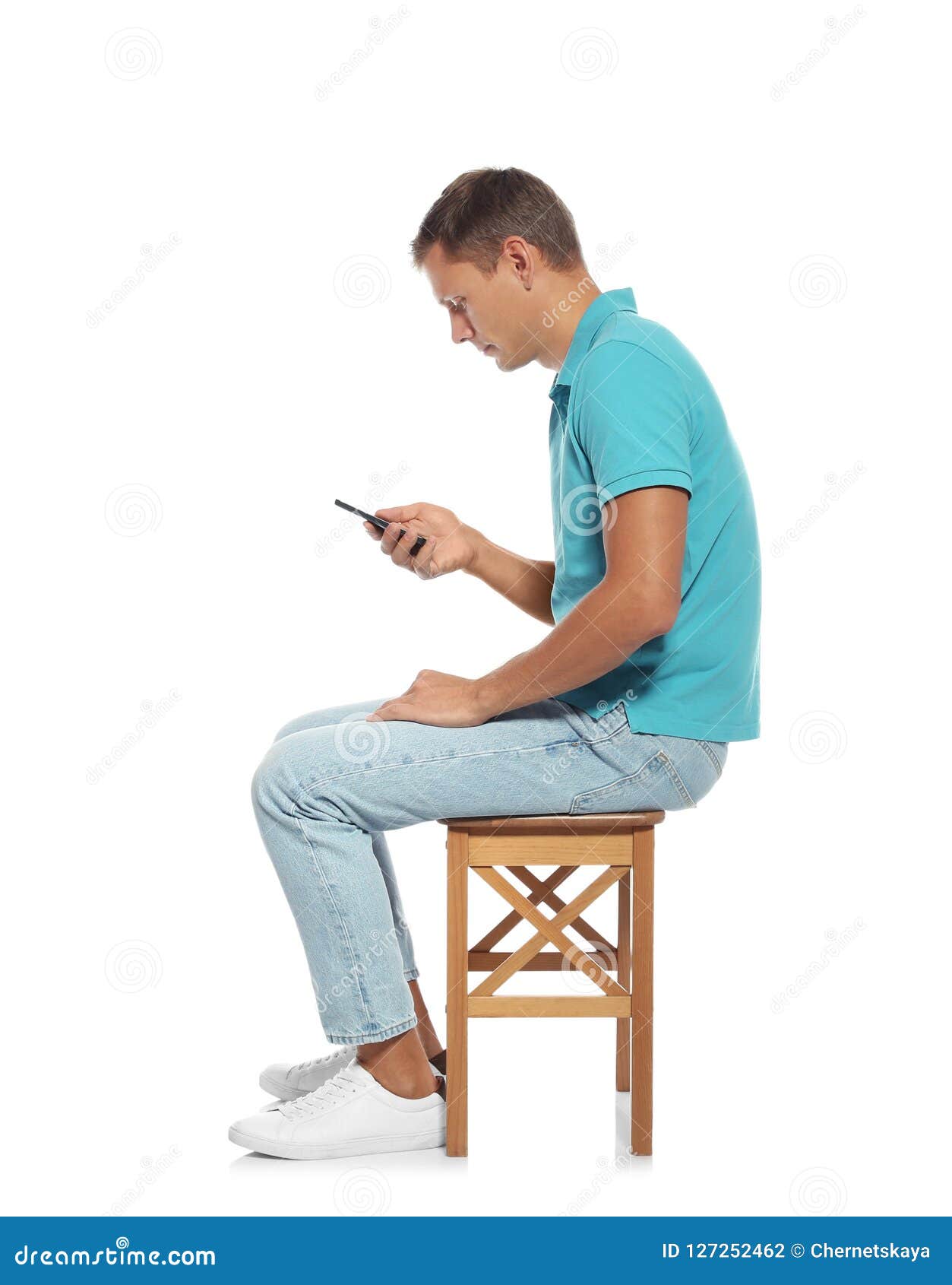 Man With Poor Posture Using Smartphone While Sitting On Stool