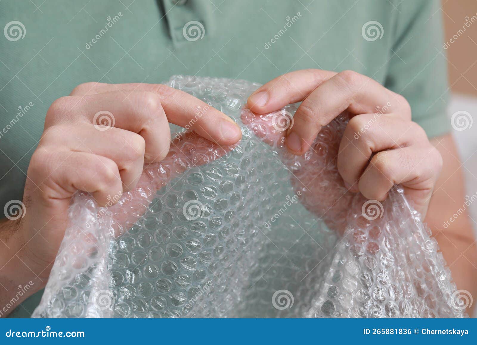 Man Popping Bubble Wrap, Closeup View. Stress Relief Stock Photo
