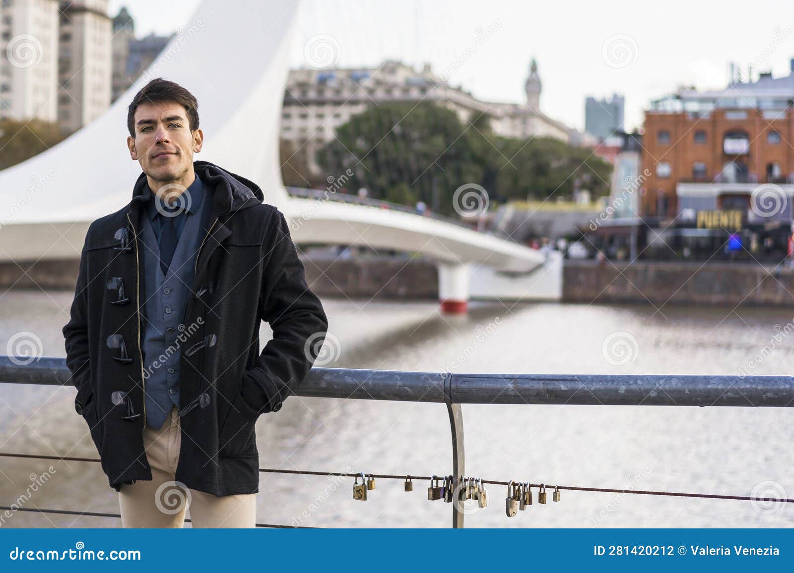 a man posing to camera near puente de la mujer (woman's bridge) in puerto madero, buenos aires